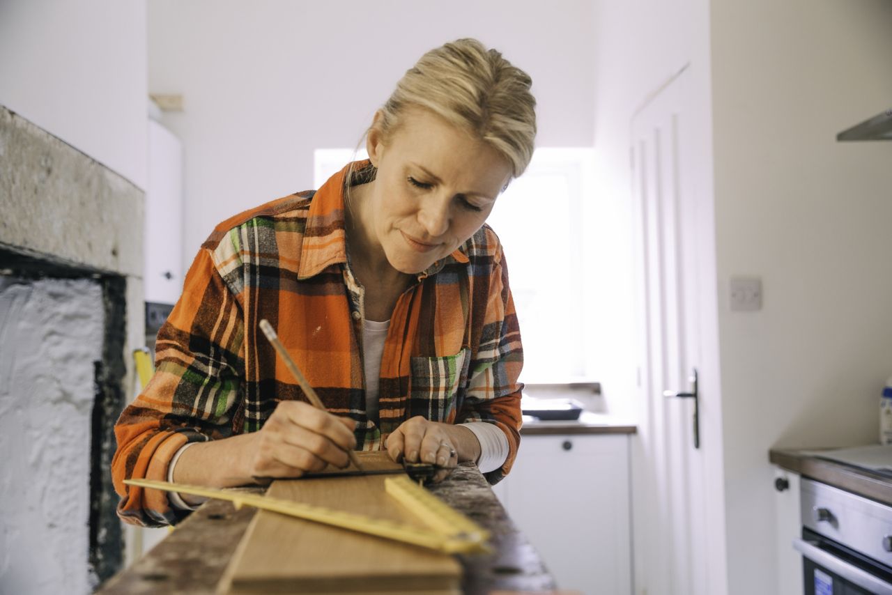 Woman measuring wood for DIY home improvement project