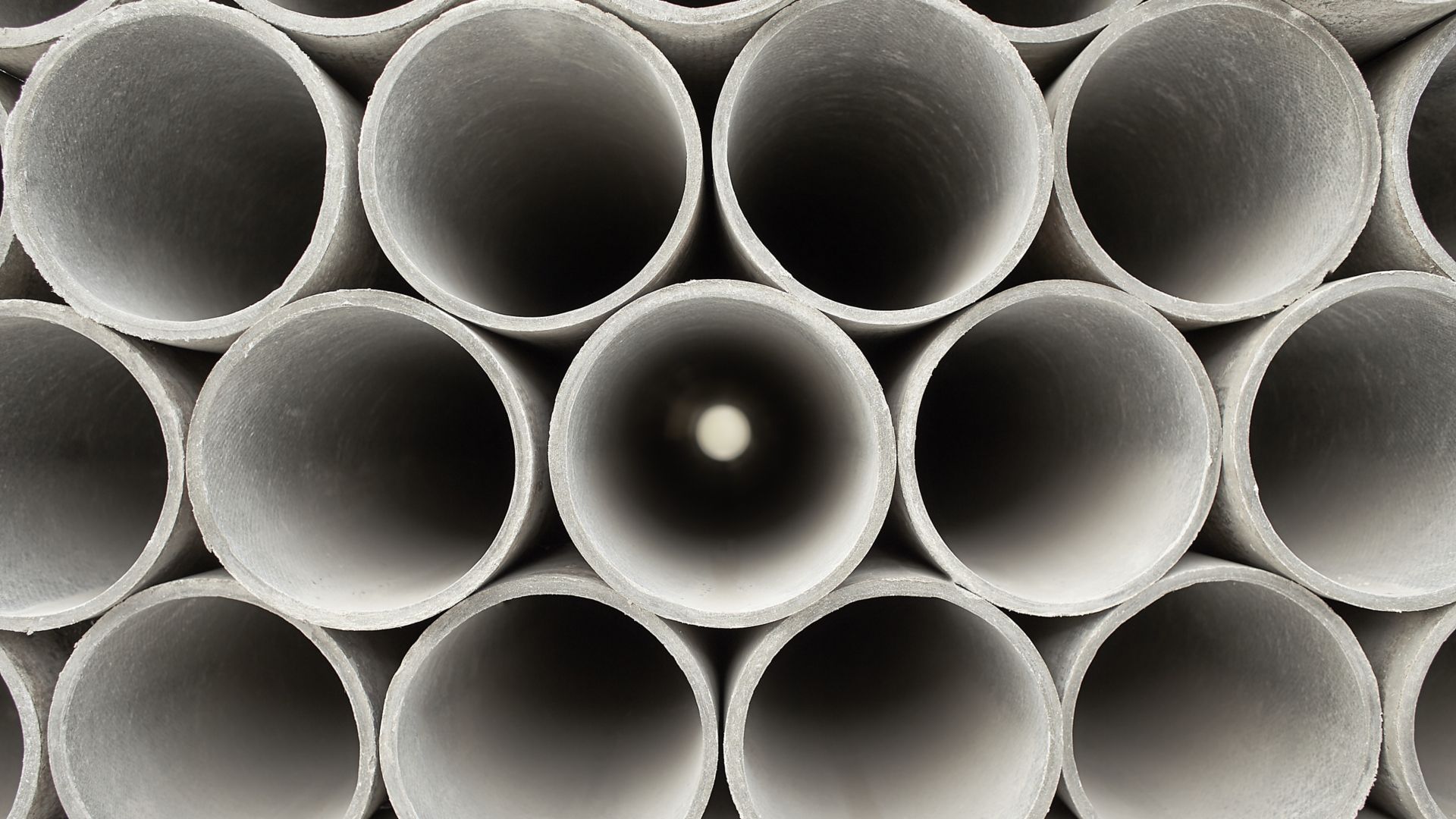Pipes at the hardware store used for the construction. Close up concrete, cement pipes stacking, pattern background. Asbestos pipes for irrigation.