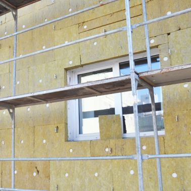 Install Rock Mineral Wool Insulation. Energy efficiency house wall  renovation for energy saving. Exterior house wall heat insulation with mineral wool, building under construction.