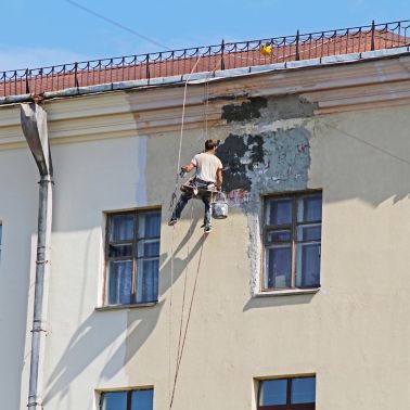 Minsk, Belarus - August 08, 2013: Builder worker reconstructing the facade of building in Minsk