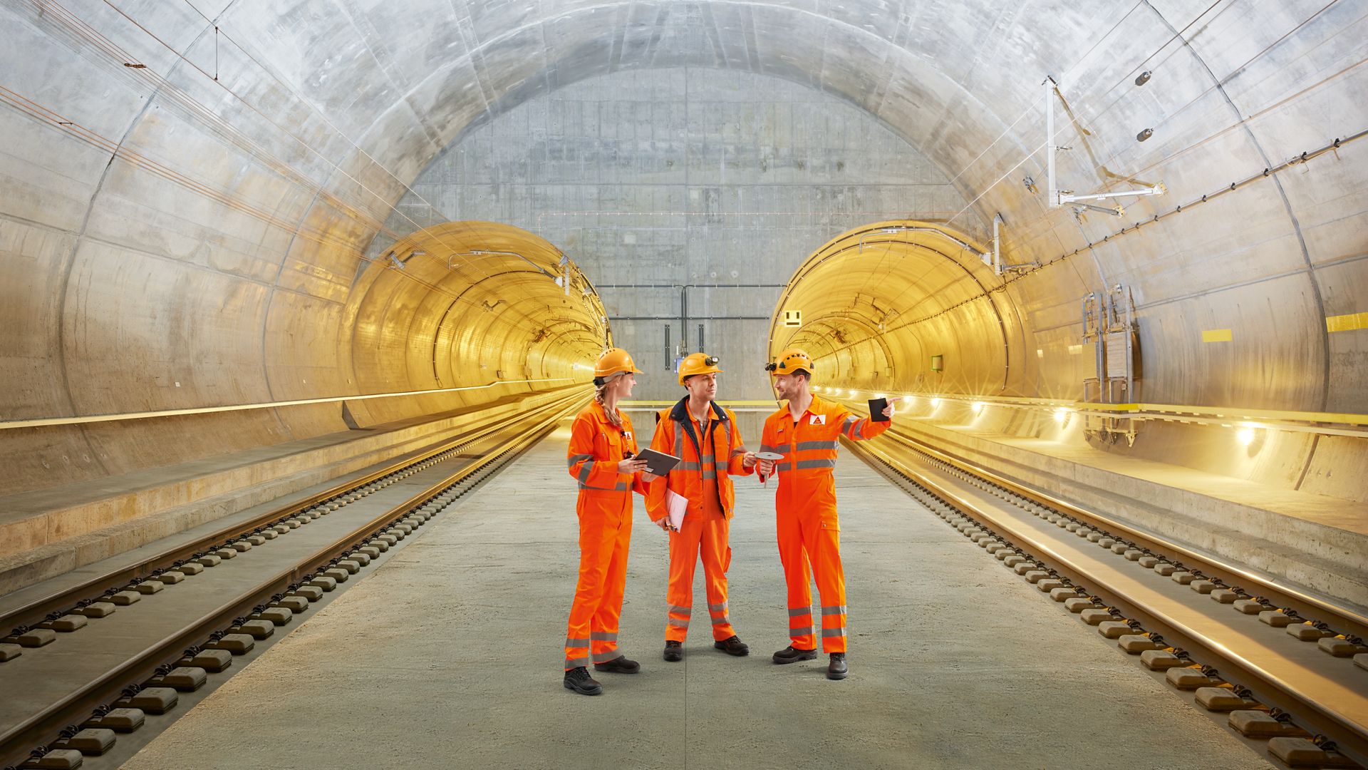 Three construction workers talking inside Gotthard Tunnel in Switzerland