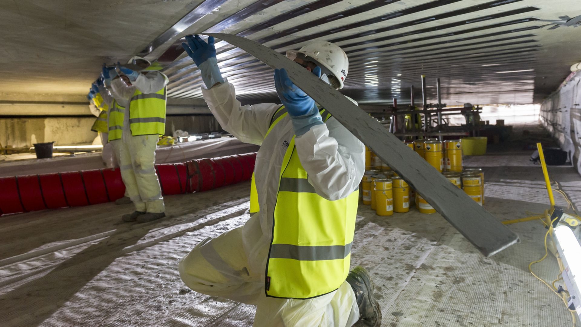 Men applying Sika CarboDur carbon fiber plates for structural strengthening