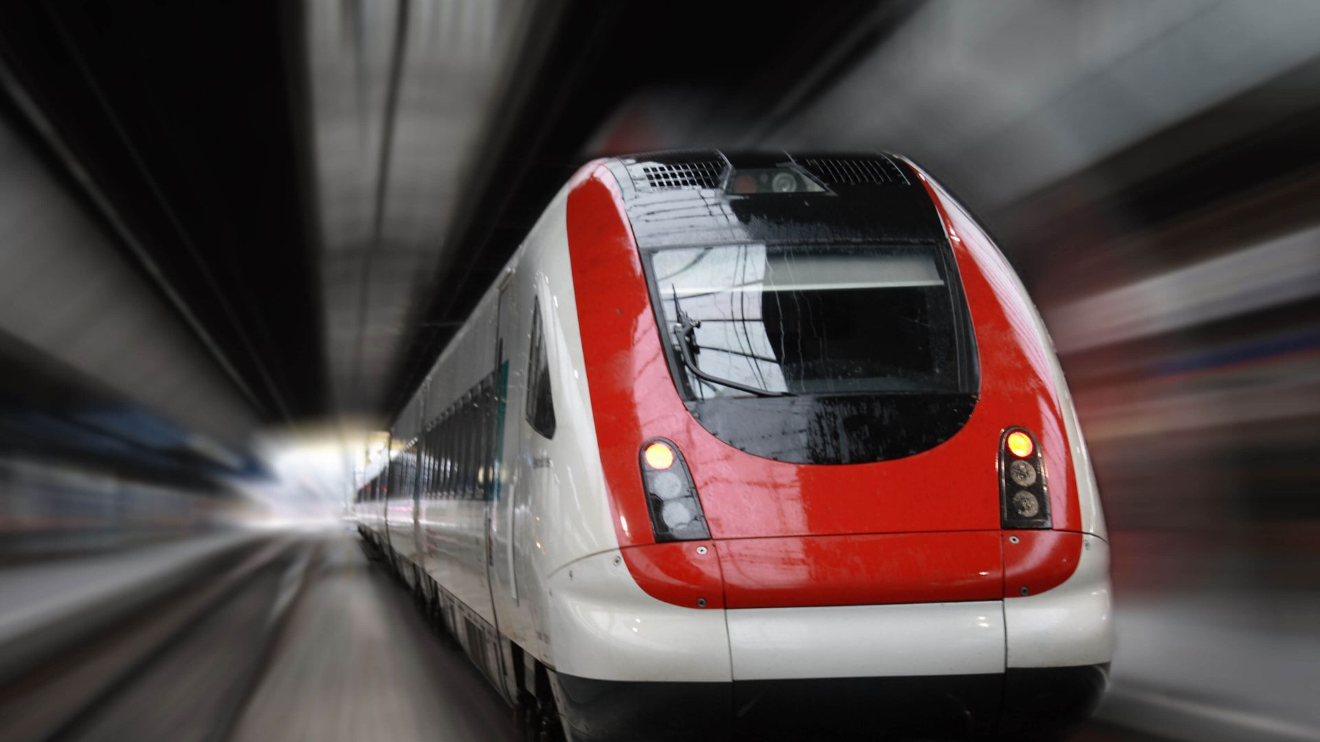 high speed trail with red trim speeding through tunnel.