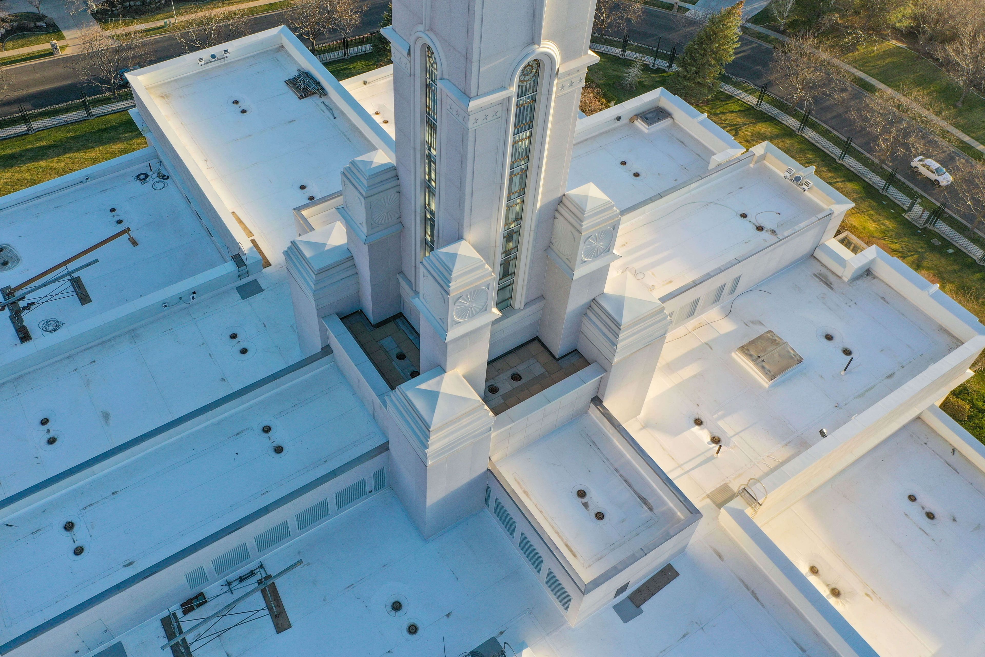 Close up aerial view of the Bountiful Temple with a spire in the center and white roofing membrane on the roof