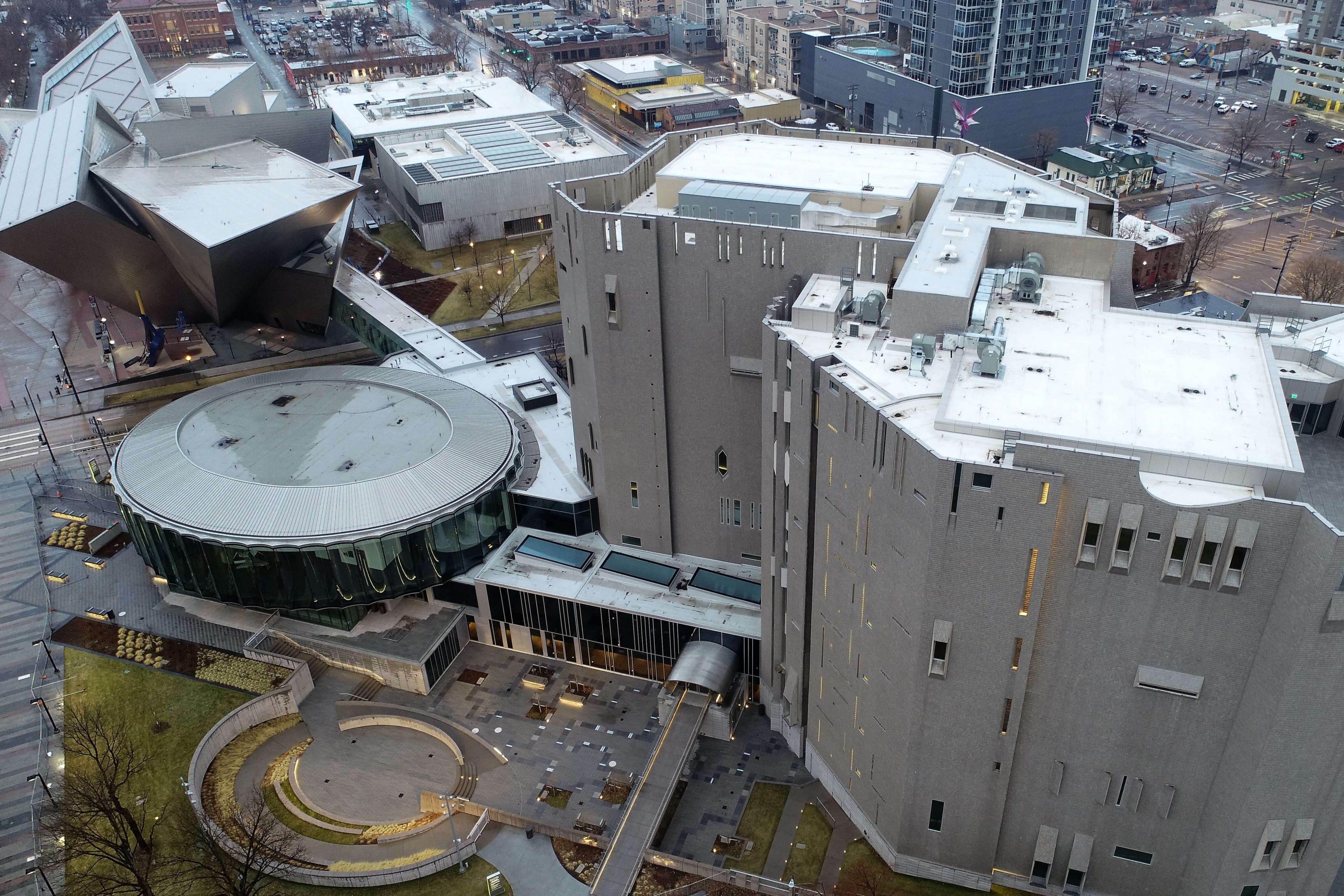Aerial view of the Denver Art Museum with a Sarnafil white roof membrane on top. Denver city buildings can be seen around the art museum.