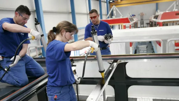 Workers assembling industrial vehicle components