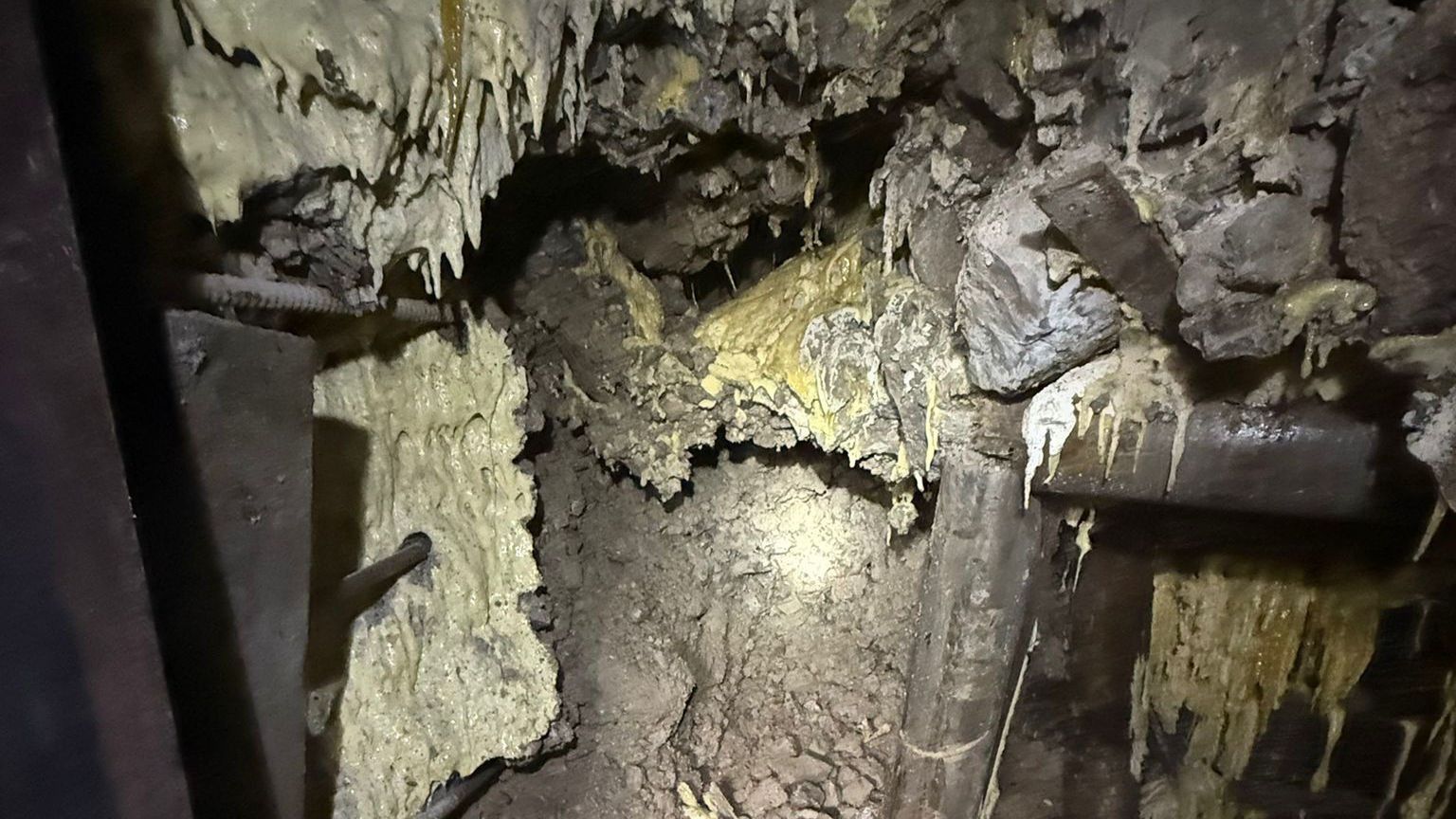 Underground cave with stalactites and debris
