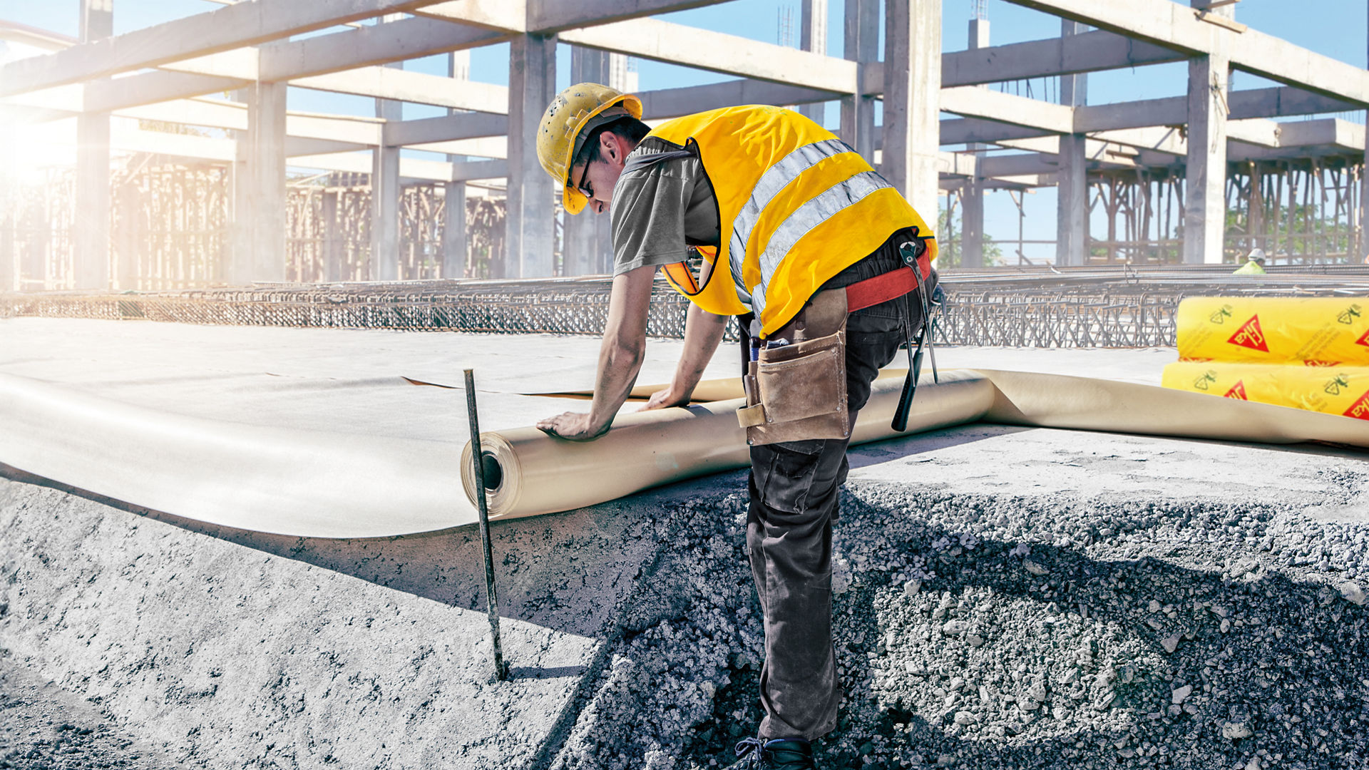 Construction worker laying waterproof membrane