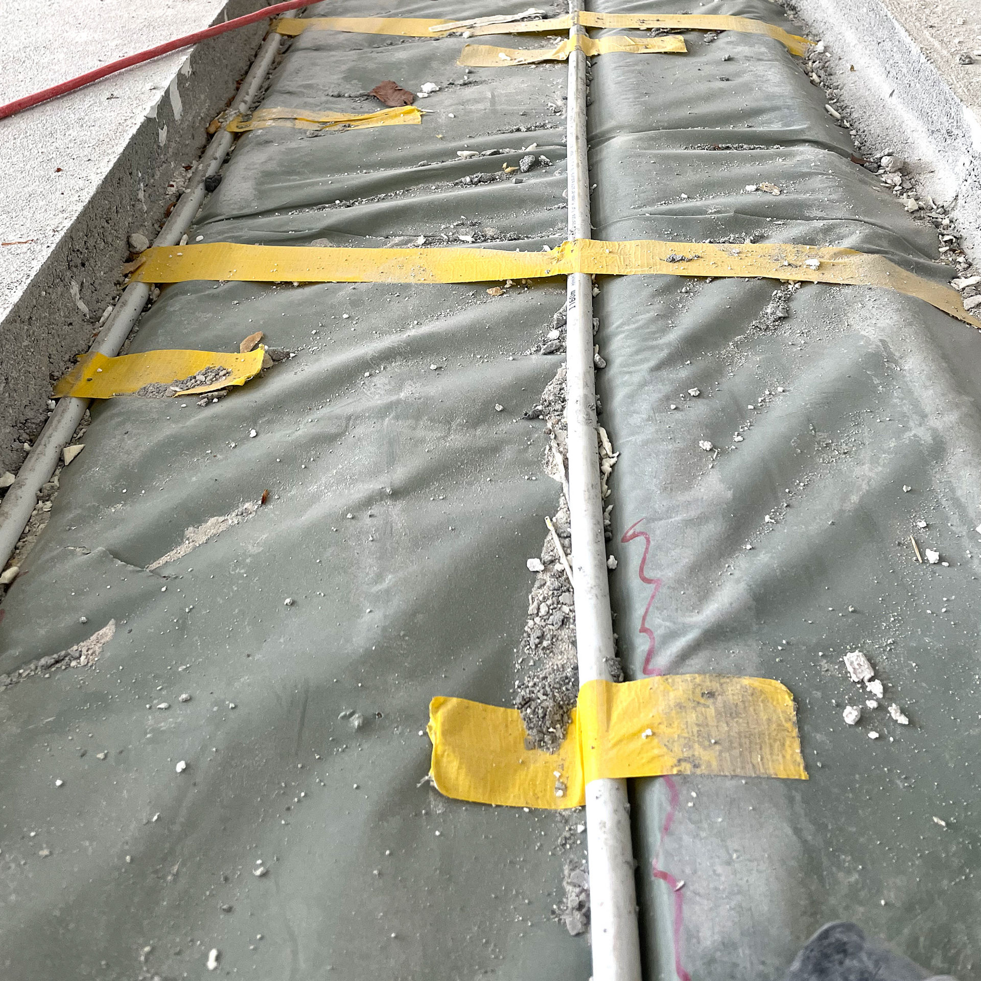 Exposed floor wiring with yellow tape