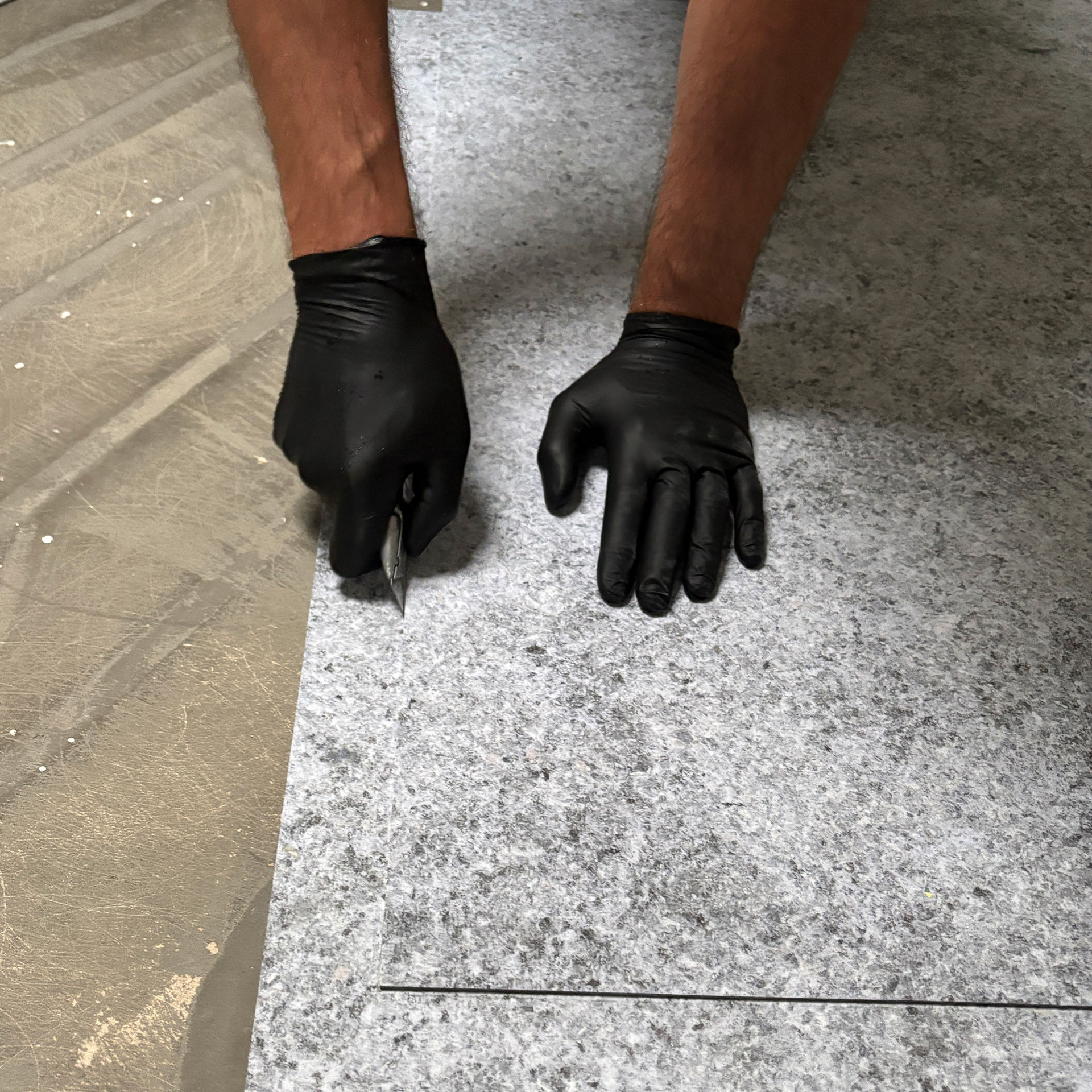 Person cutting flooring material with precision