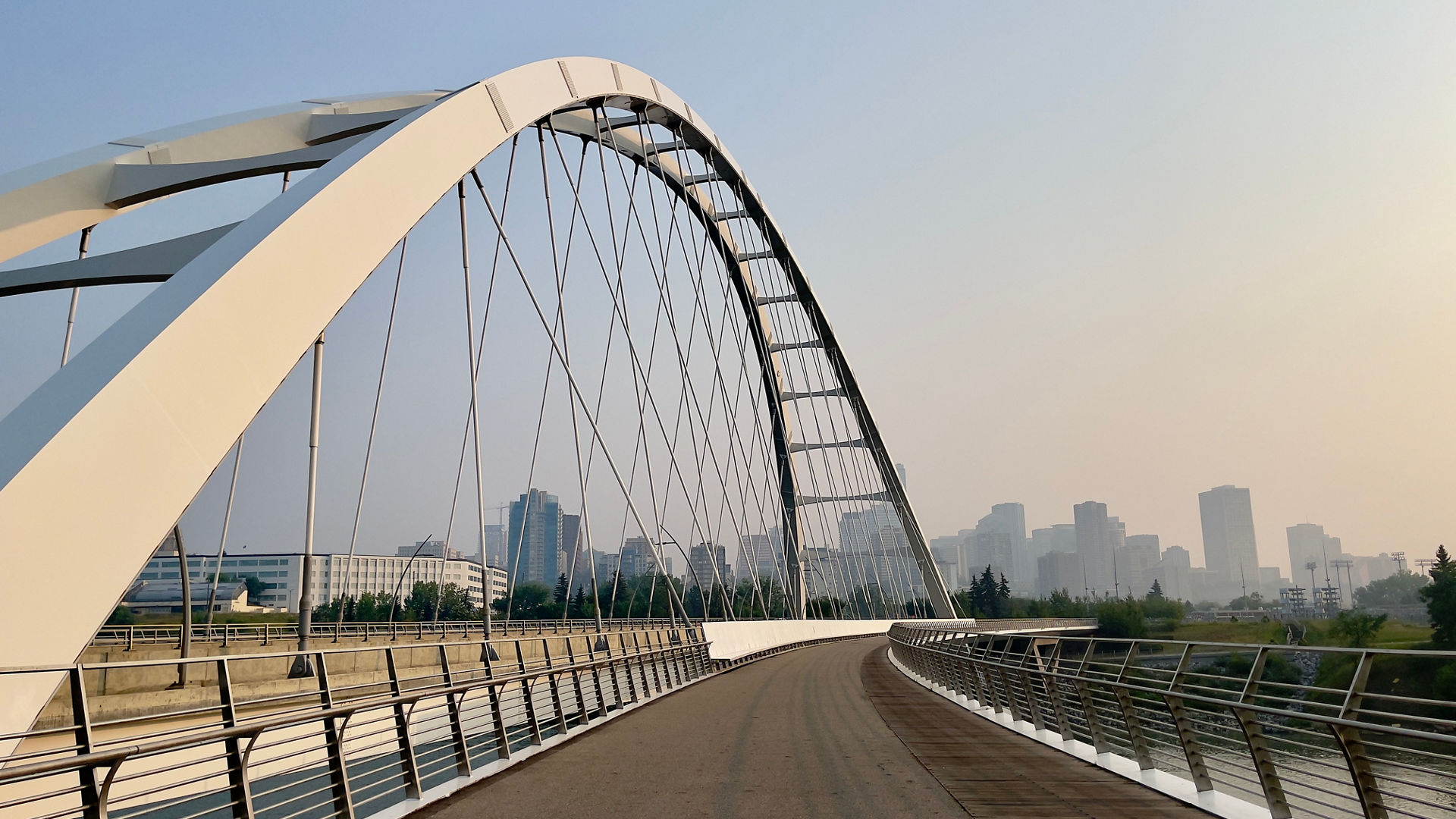 Modern arched bridge with city skyline