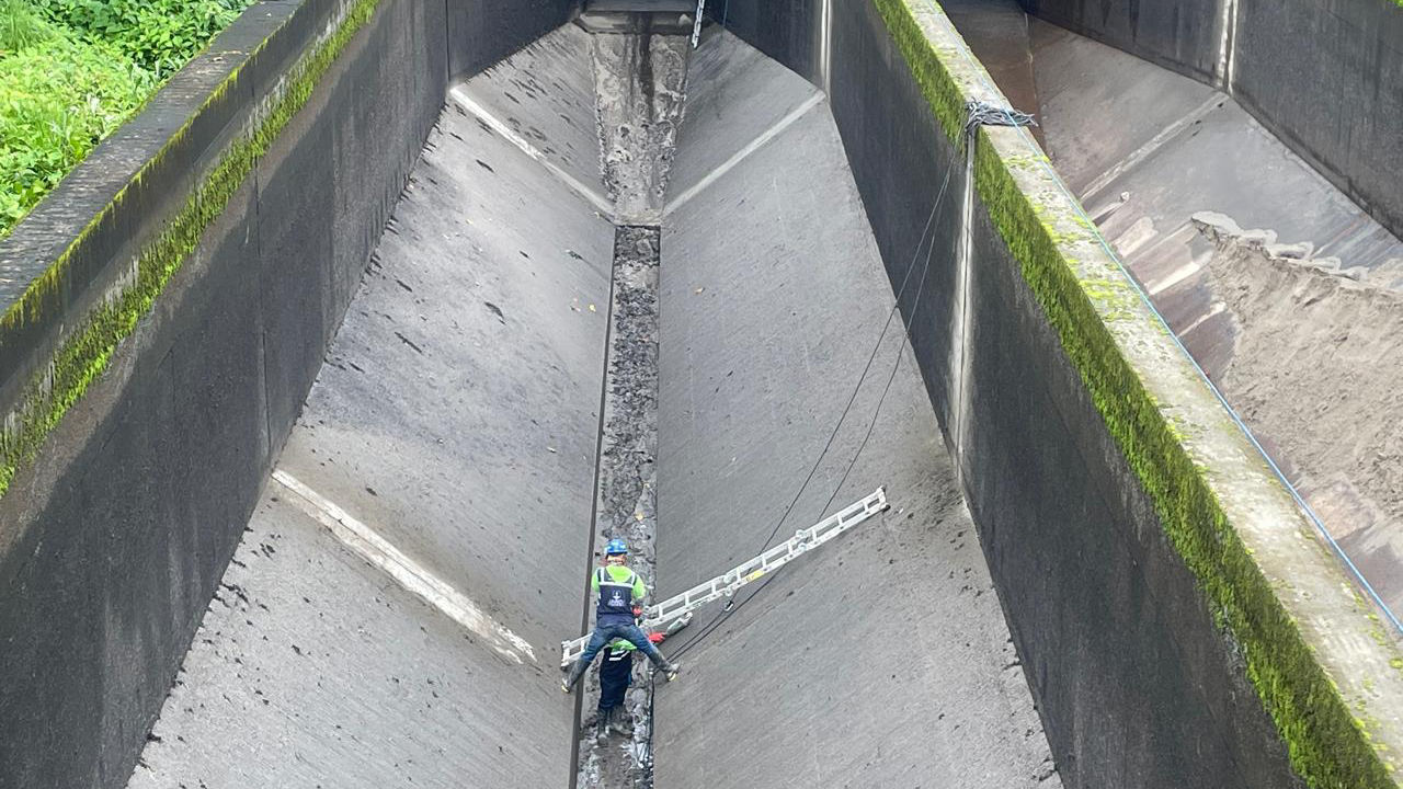 Worker Cleaning Large Concrete Drainage Channel