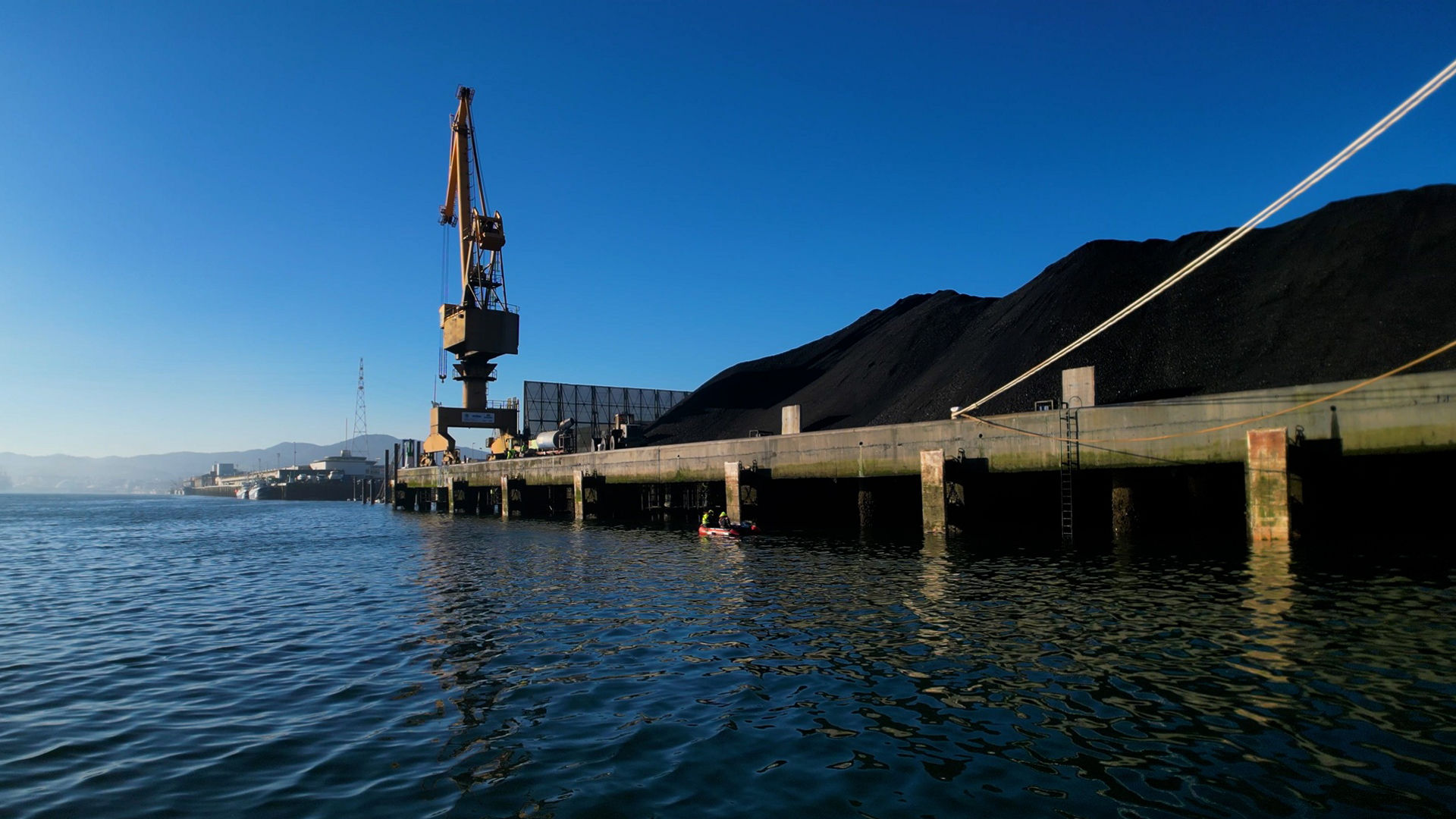 Industrial dock with crane and coal piles