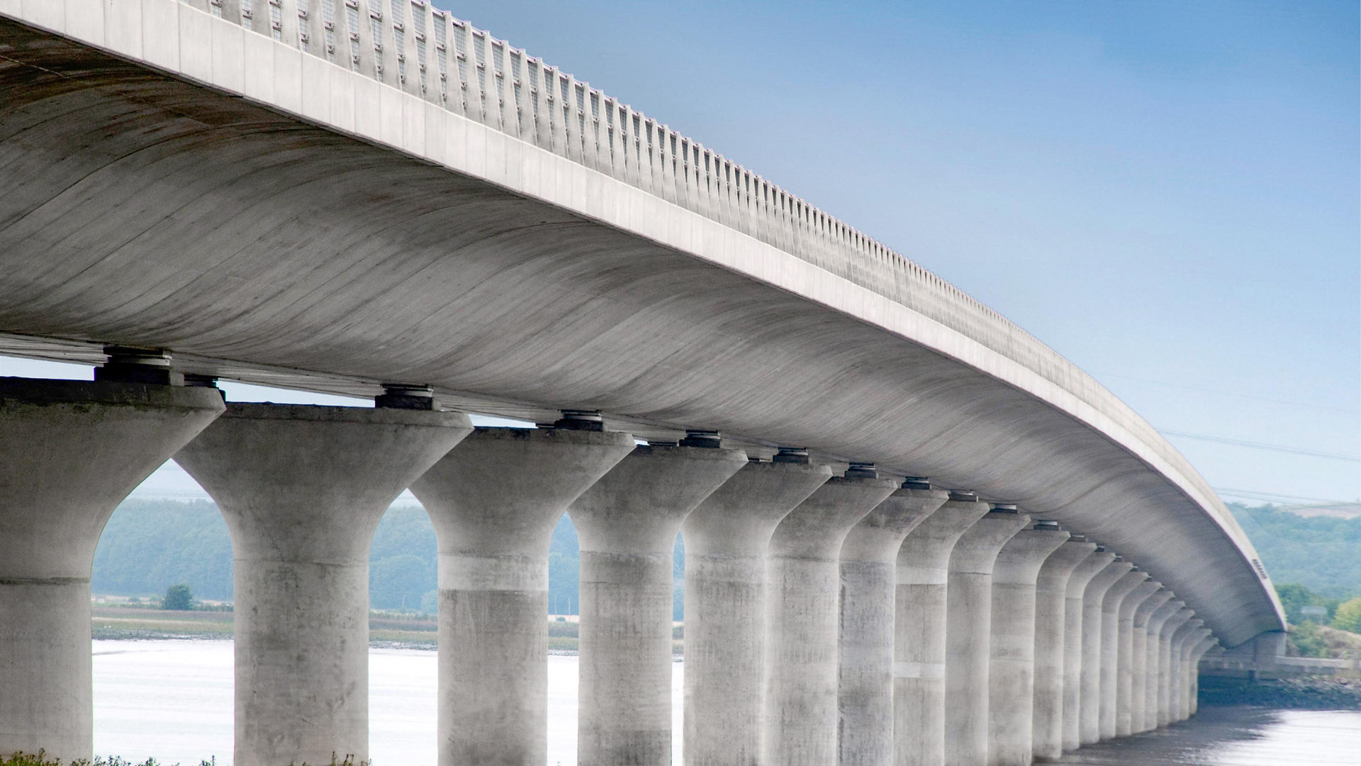 Modern concrete bridge spanning wide river landscape