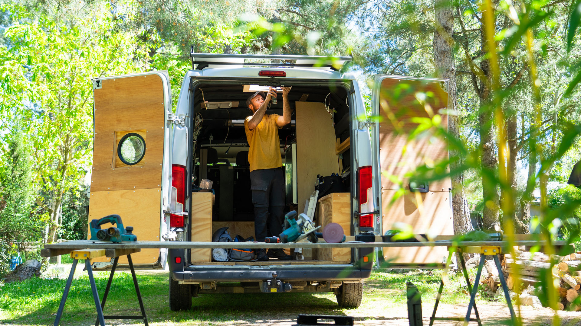 Carpenter working inside open van outdoors