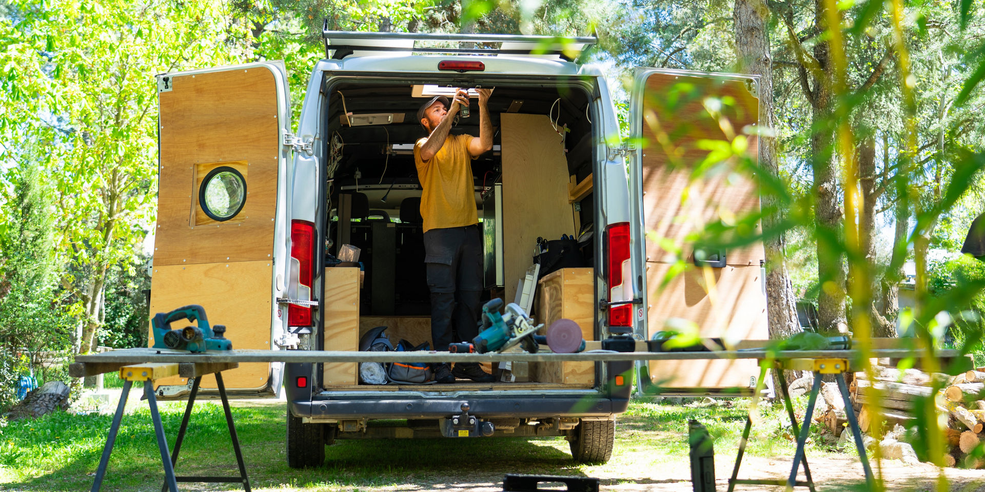 Carpenter working inside open van outdoors