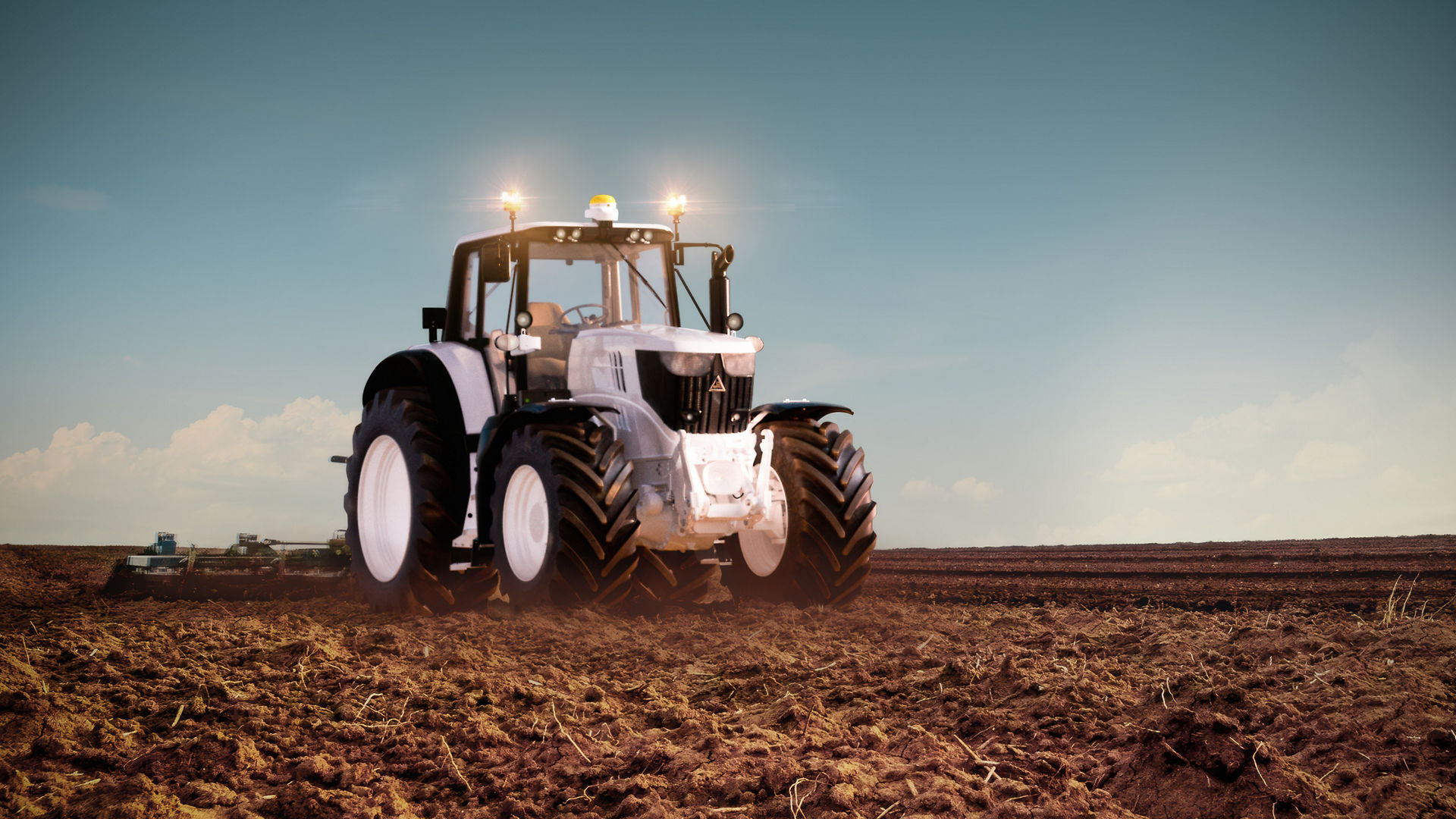 Modern tractor in a plowed field