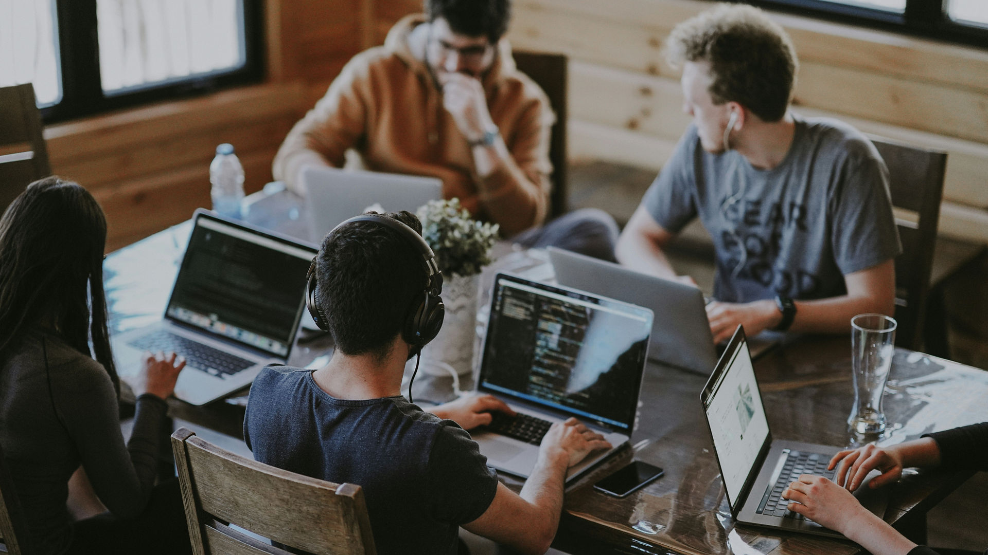 Young professionals collaborating with laptops in workspace
