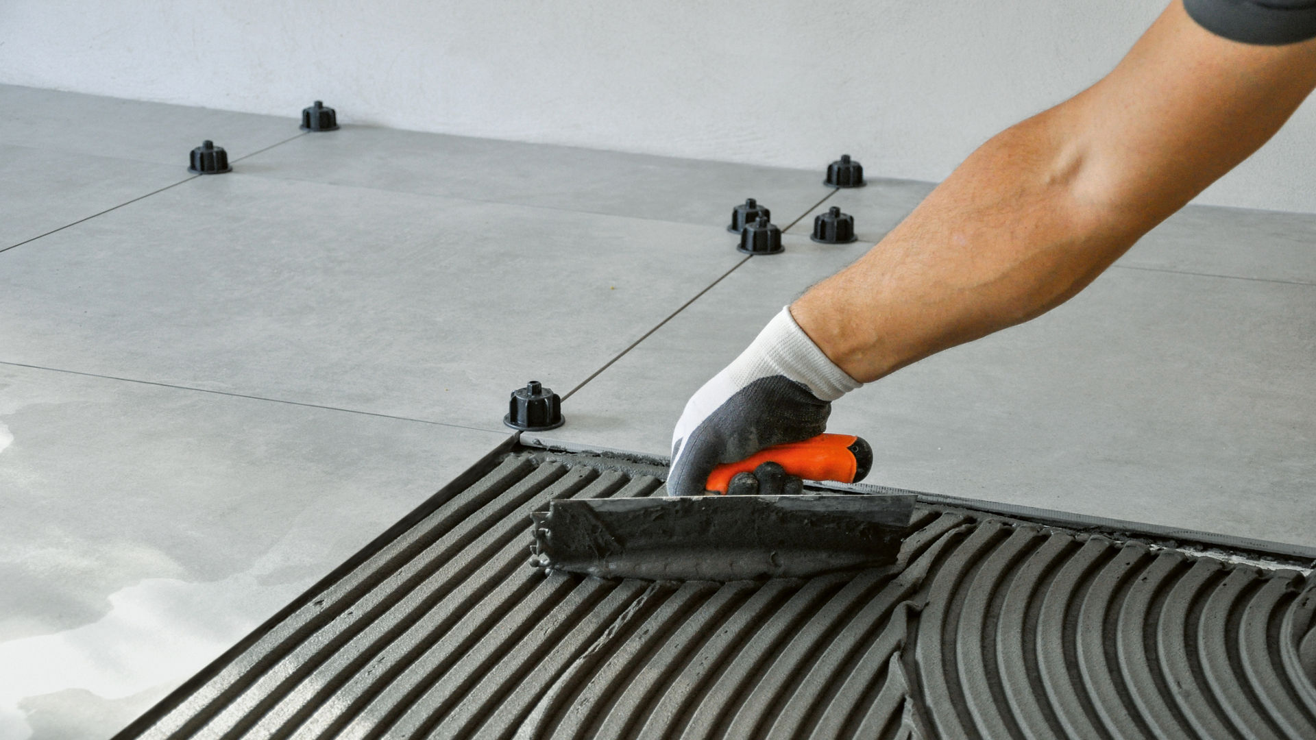 hand trowel application of leveling compound tile adhesive