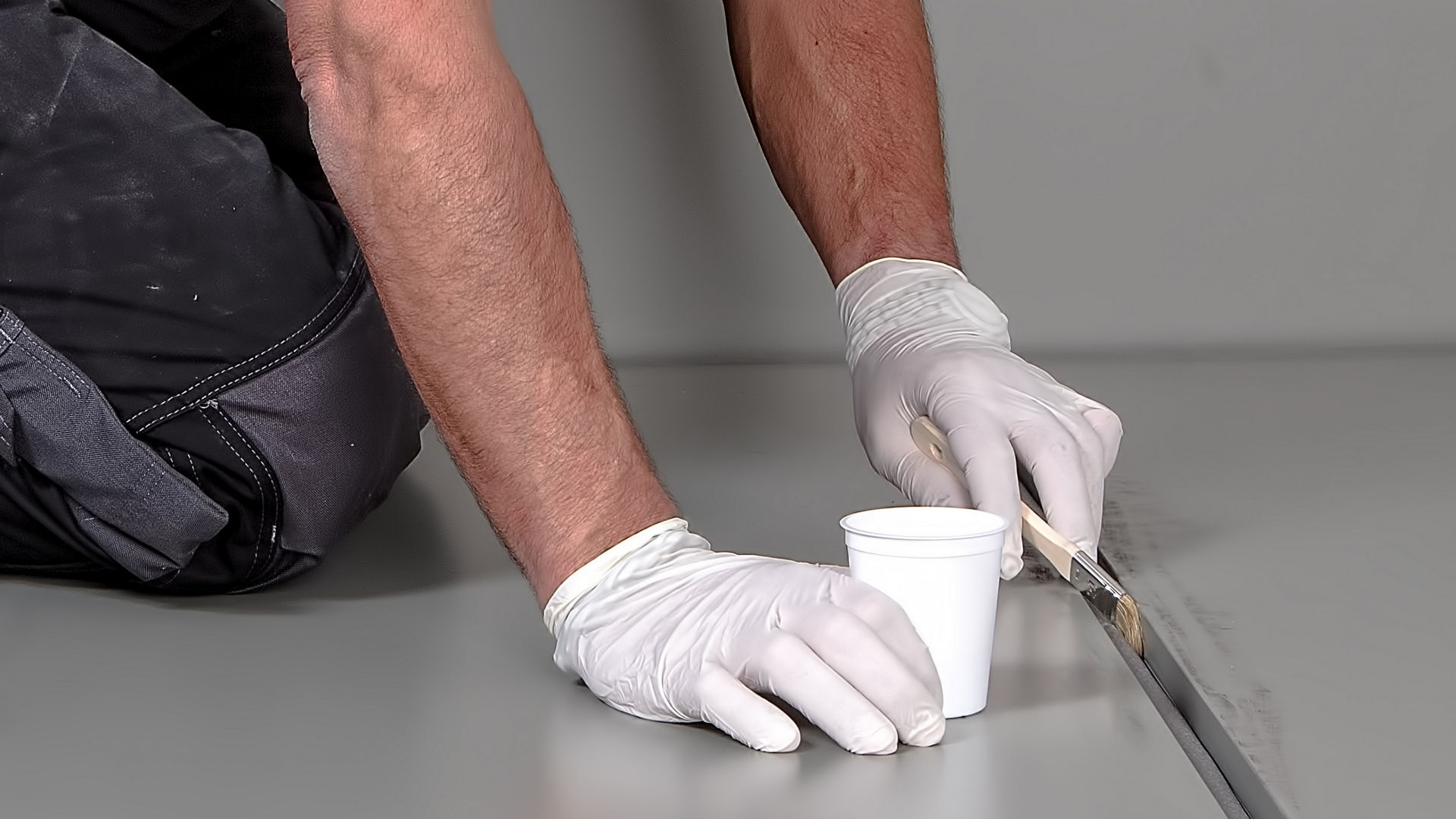 man applying primer to joint