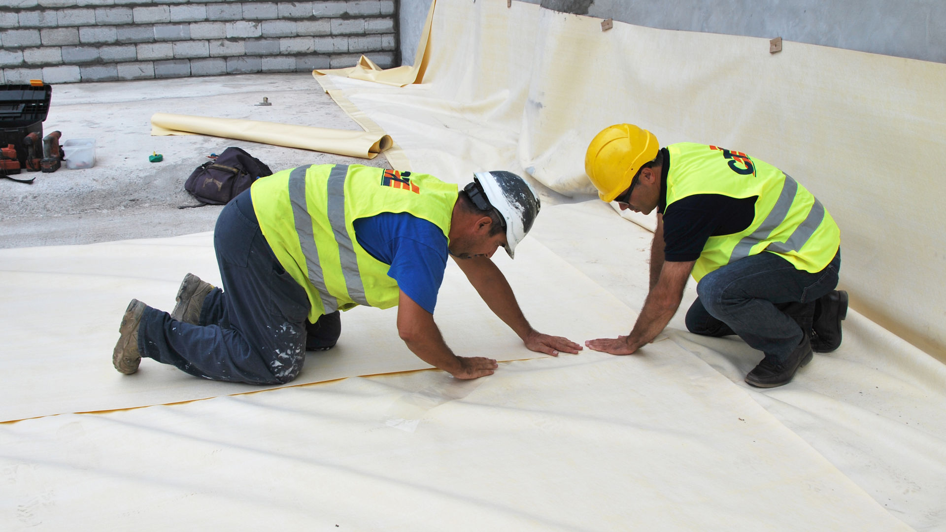 construction workers applying waterproof sheet membrane