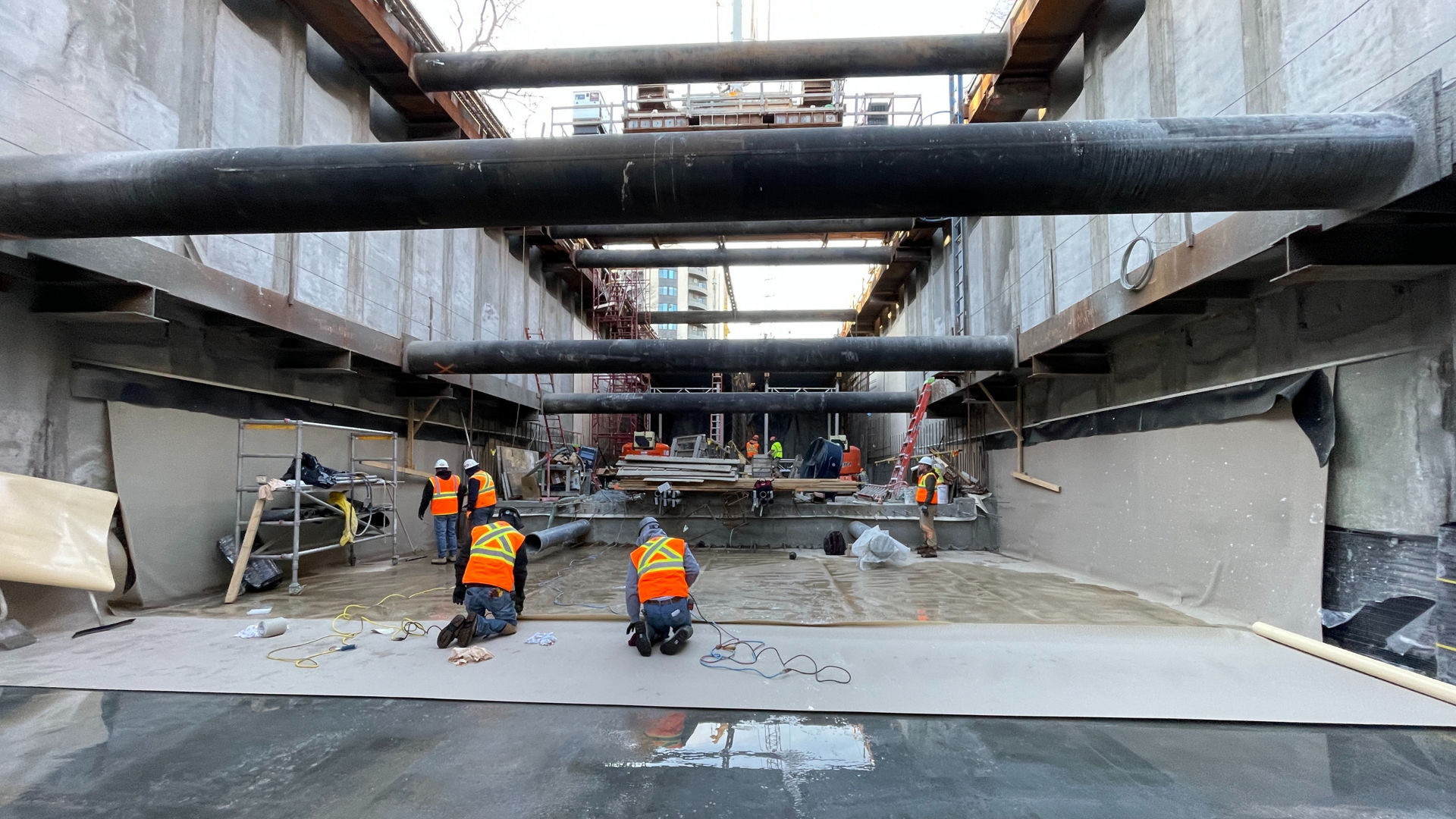 construction workers waterproofing basement