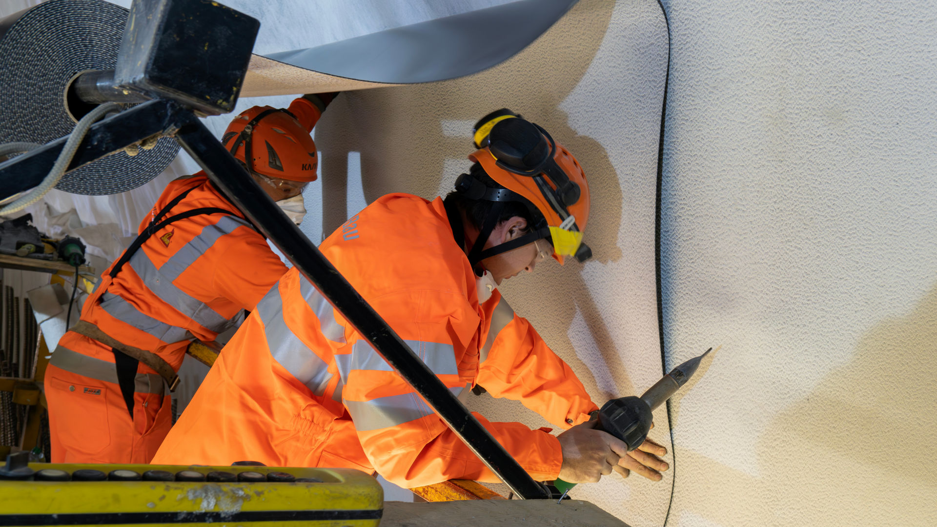 construction workers applying waterproof membrane system to wall
