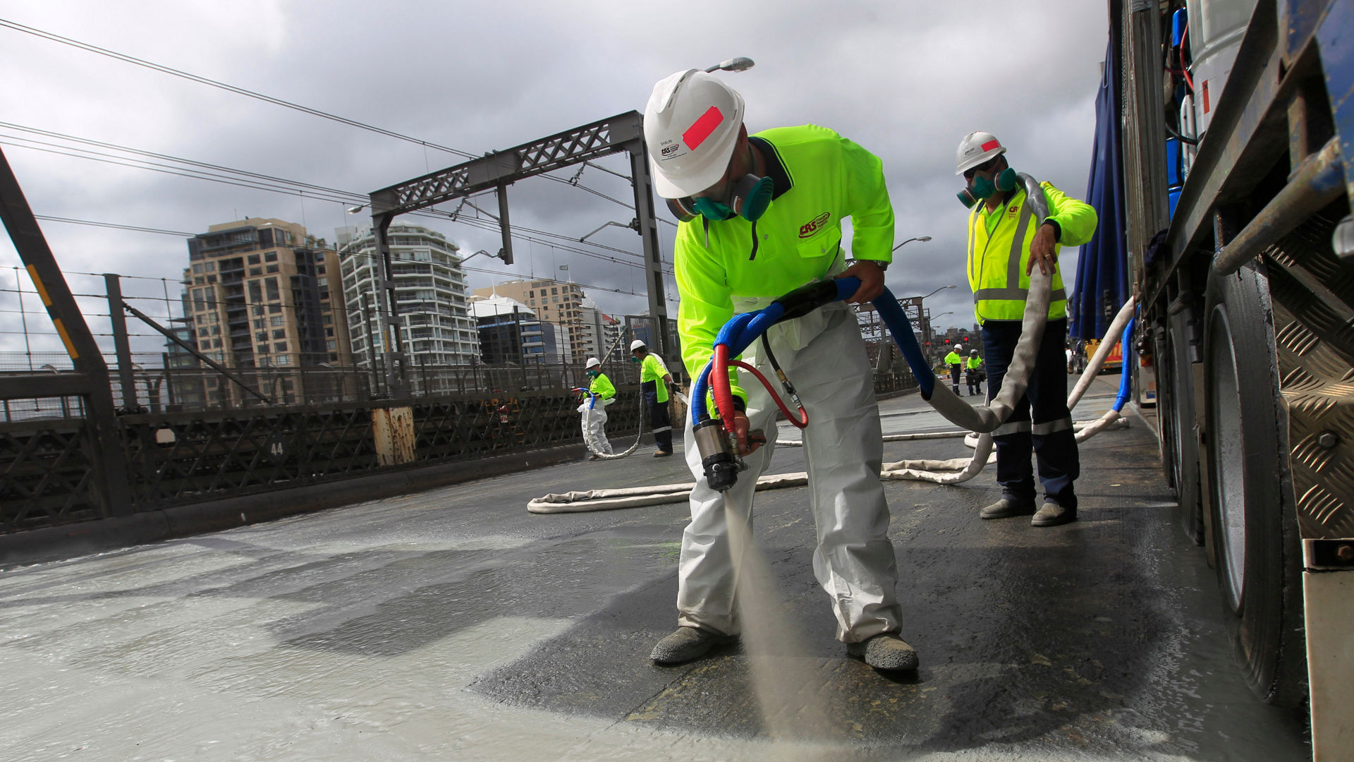 men spraying liquid applied waterproofing membrane