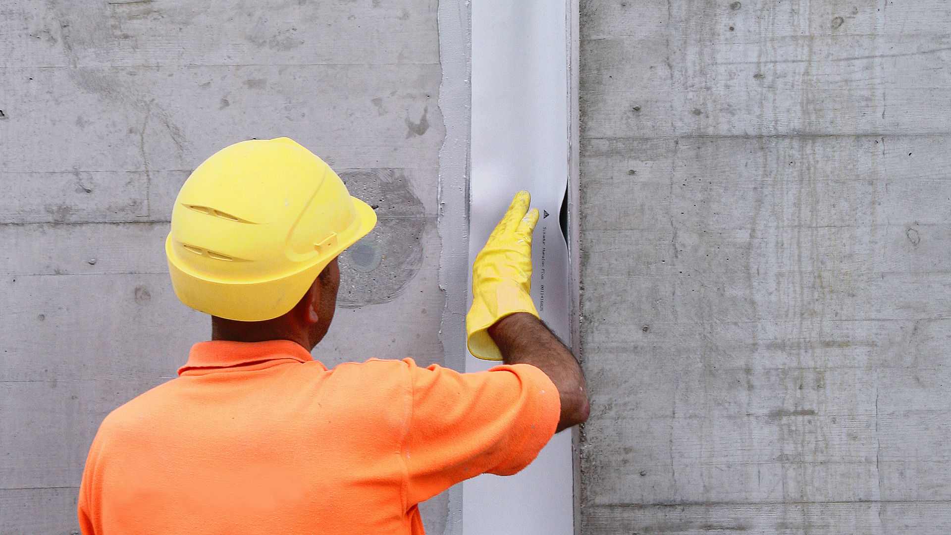 man applying joint and crack sealing tape to wall