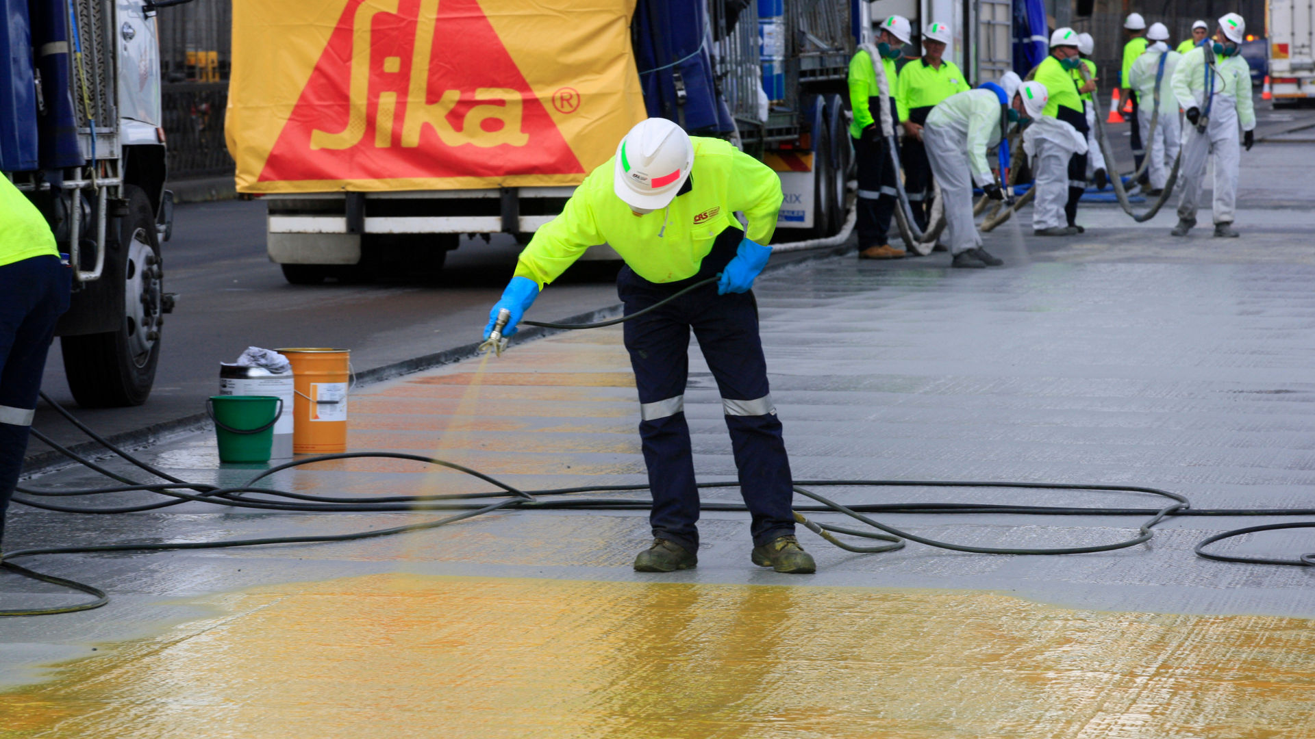 man applying waterproof coating to bridge deck