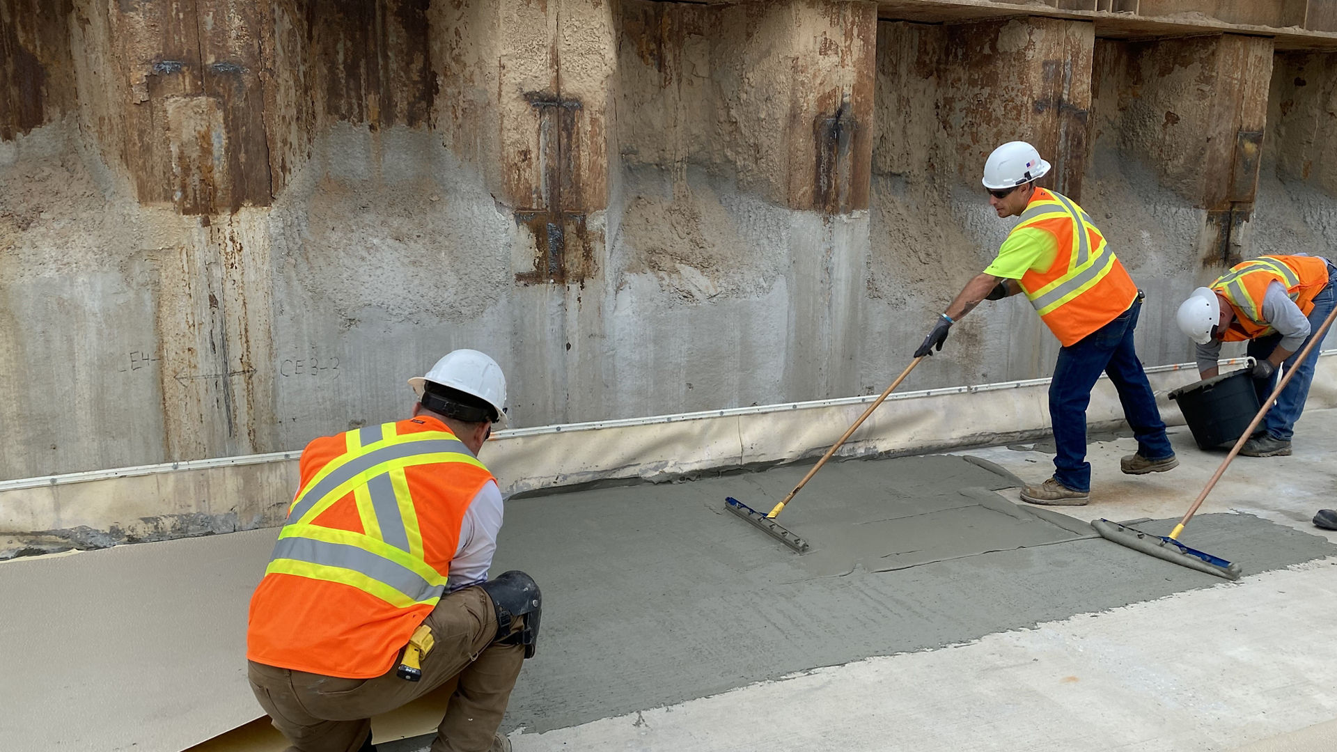men applying watertight system to basement