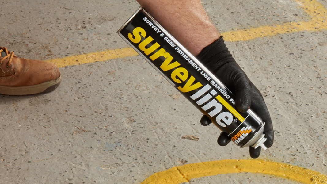 Hand using Surveyline spray on pavement
