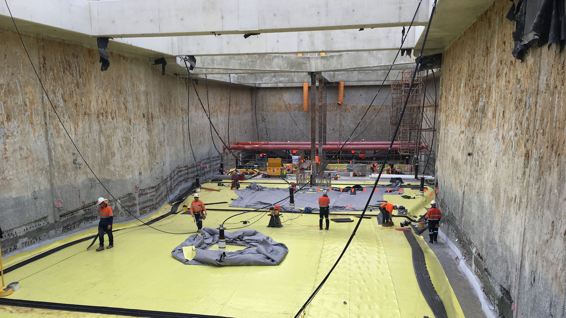 men applying waterproofing membranes to basement