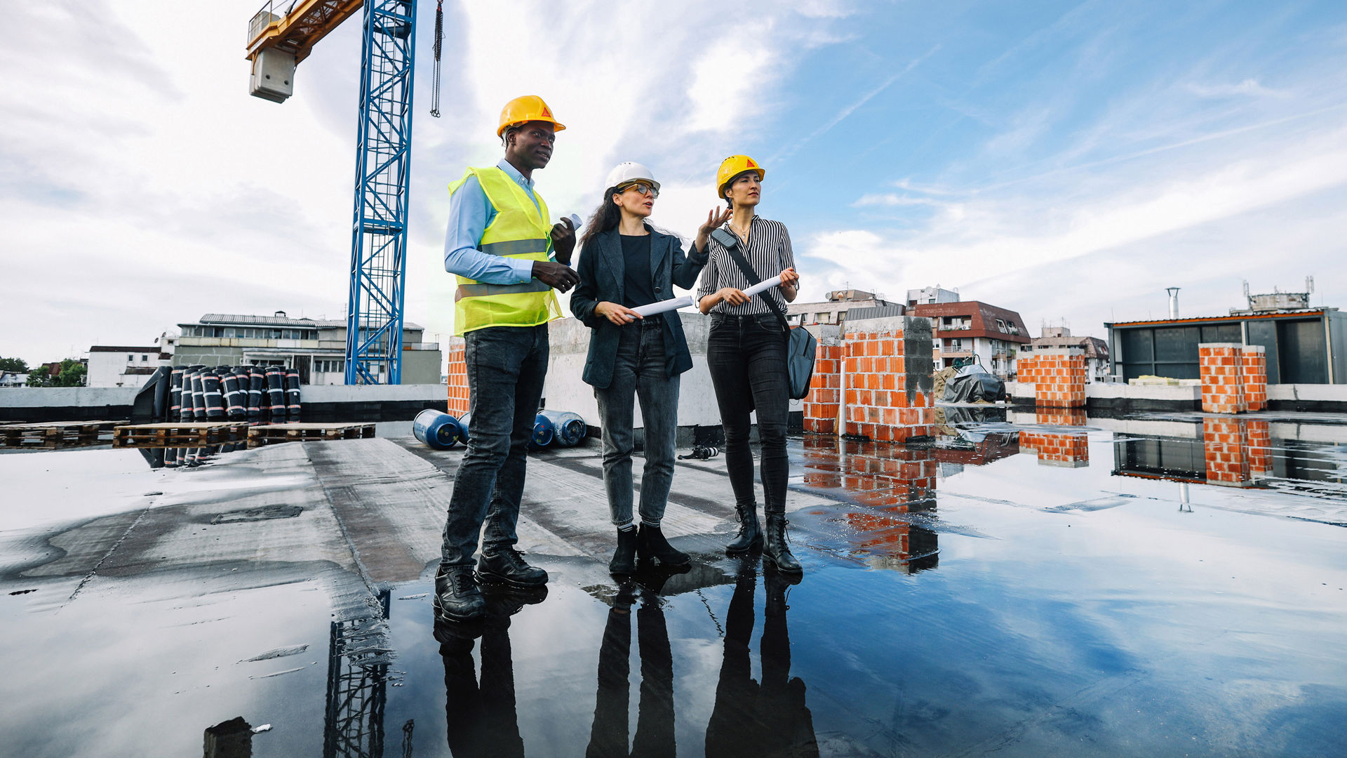 Construction team on rooftop with crane