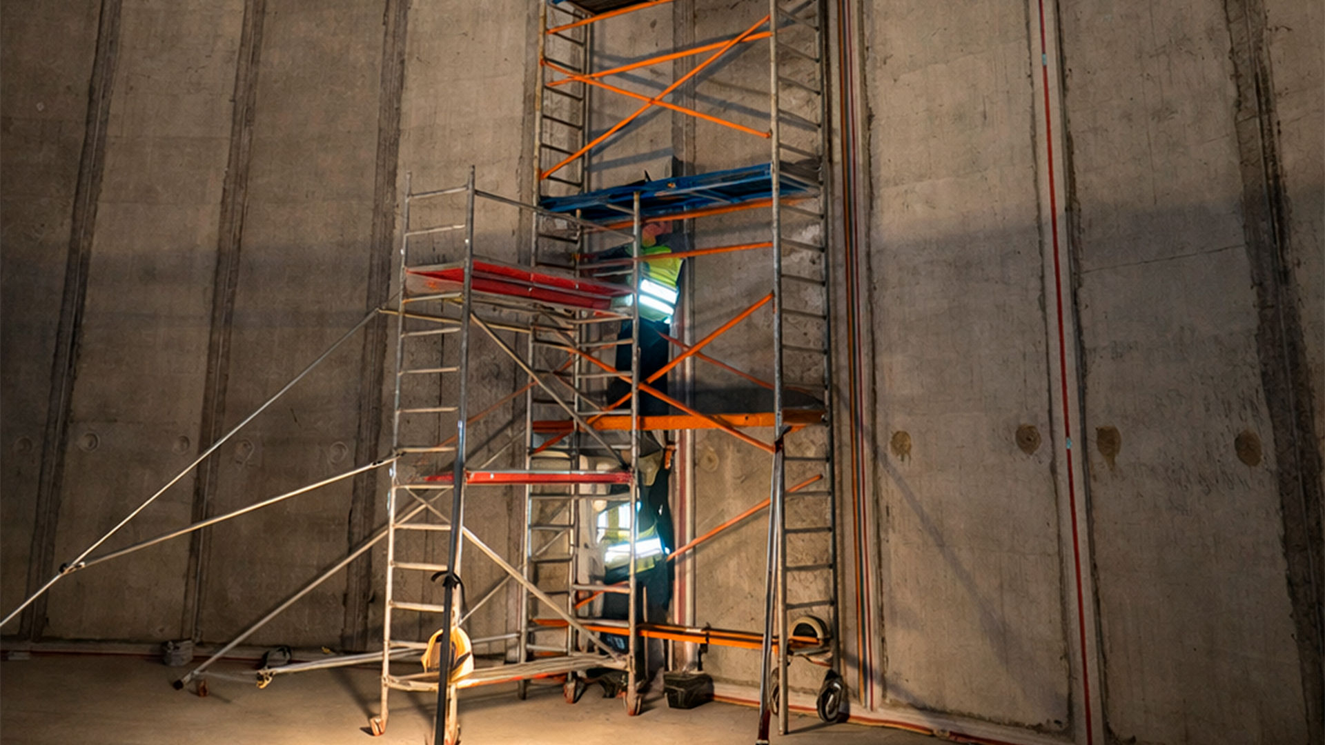 Worker on Scaffolding Inside Industrial Concrete Structure