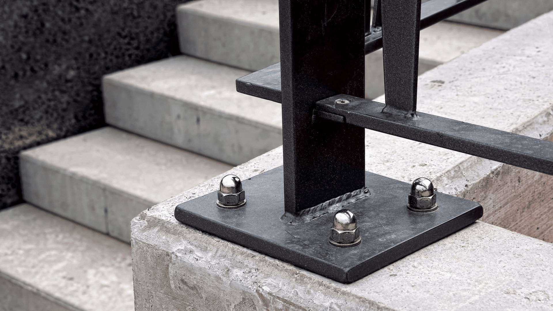 Metal railing base mounted on concrete steps