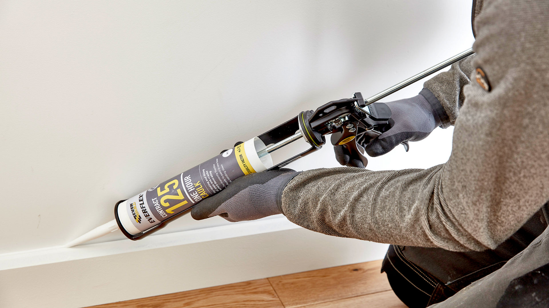 Person applying 125 Caulk to skirting boards