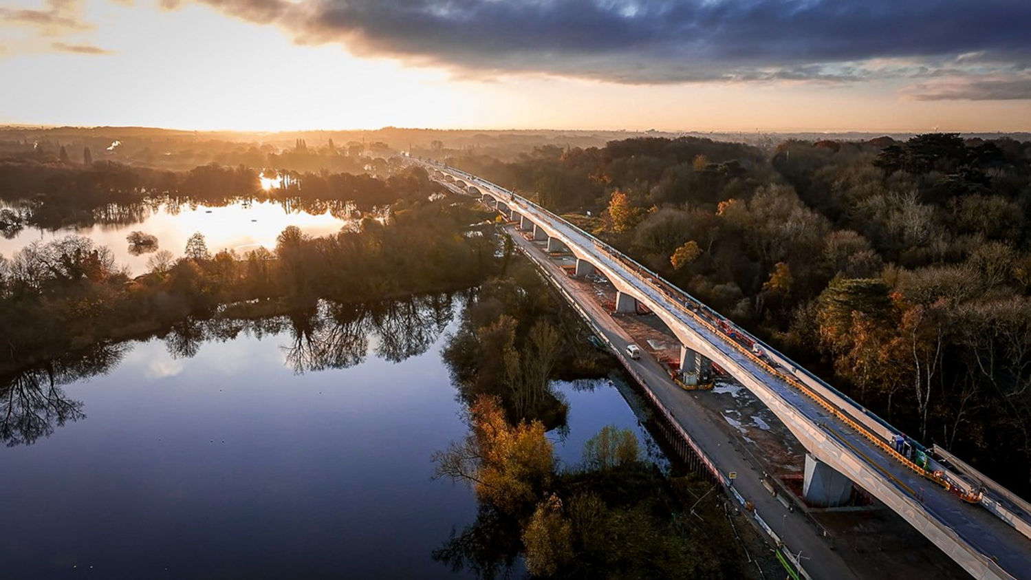 Sunrise over bridge construction and river