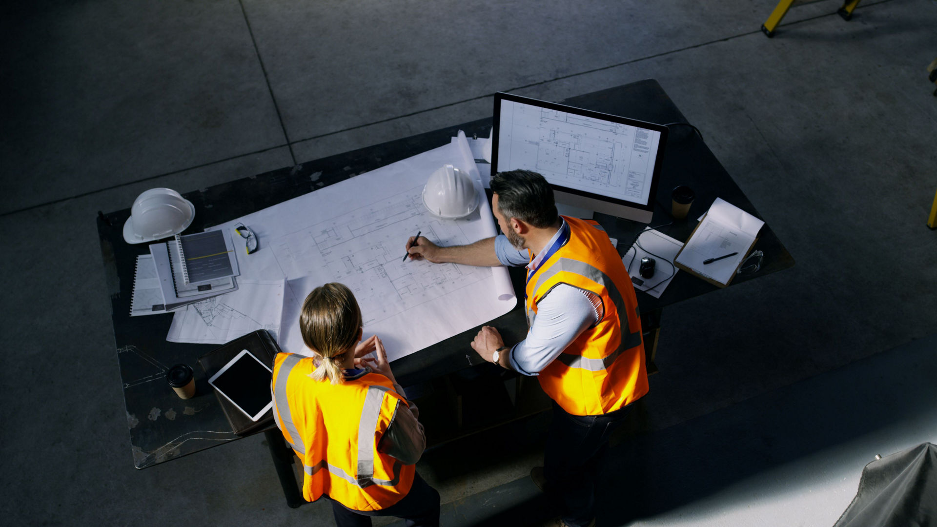 man and woman looking at drawings