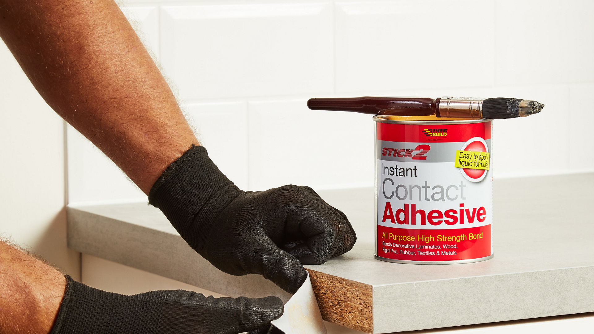 Person applying Instanf Contact Adhesive to worktop