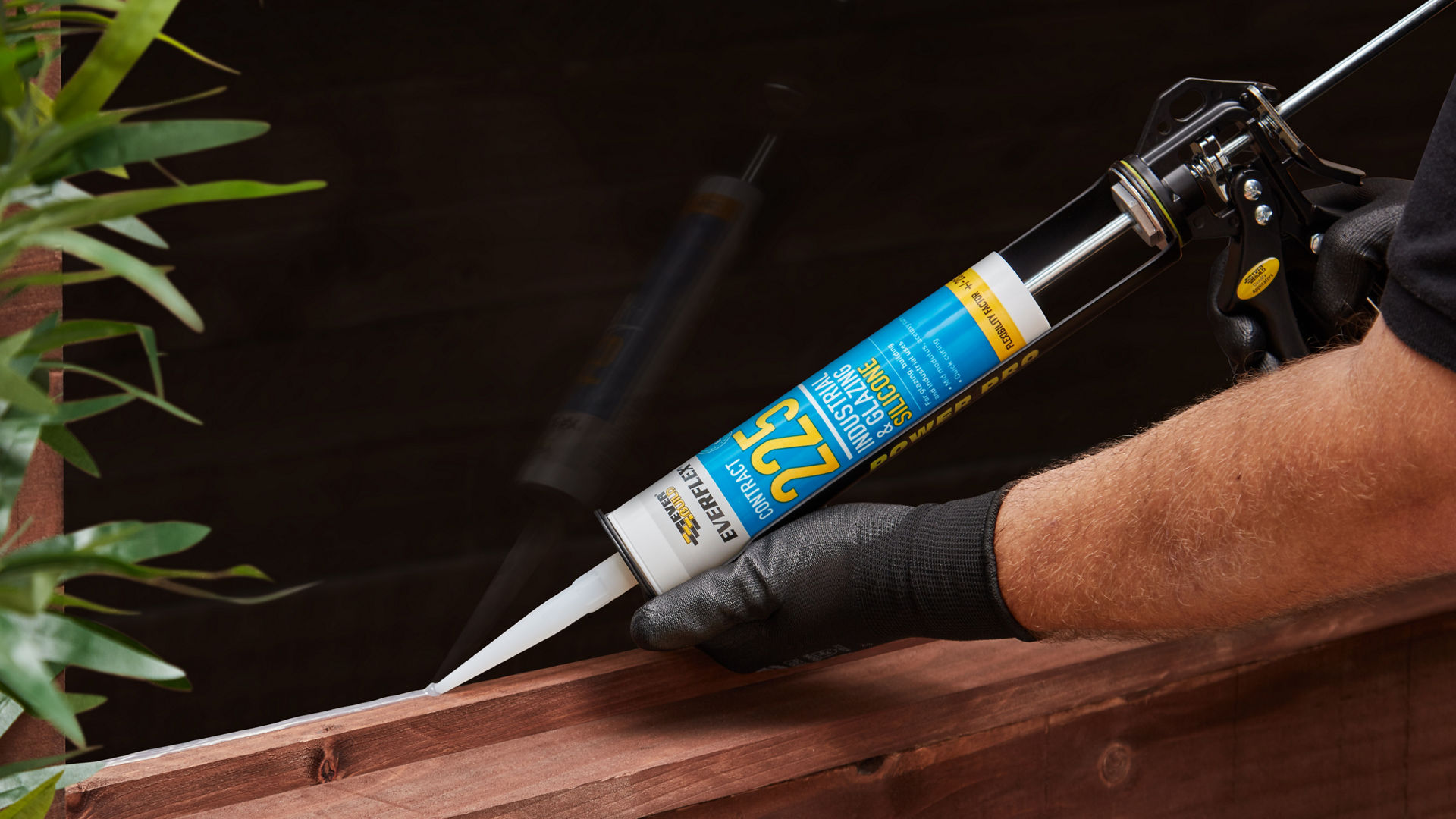 Sealant being applied to glazing panel in shed