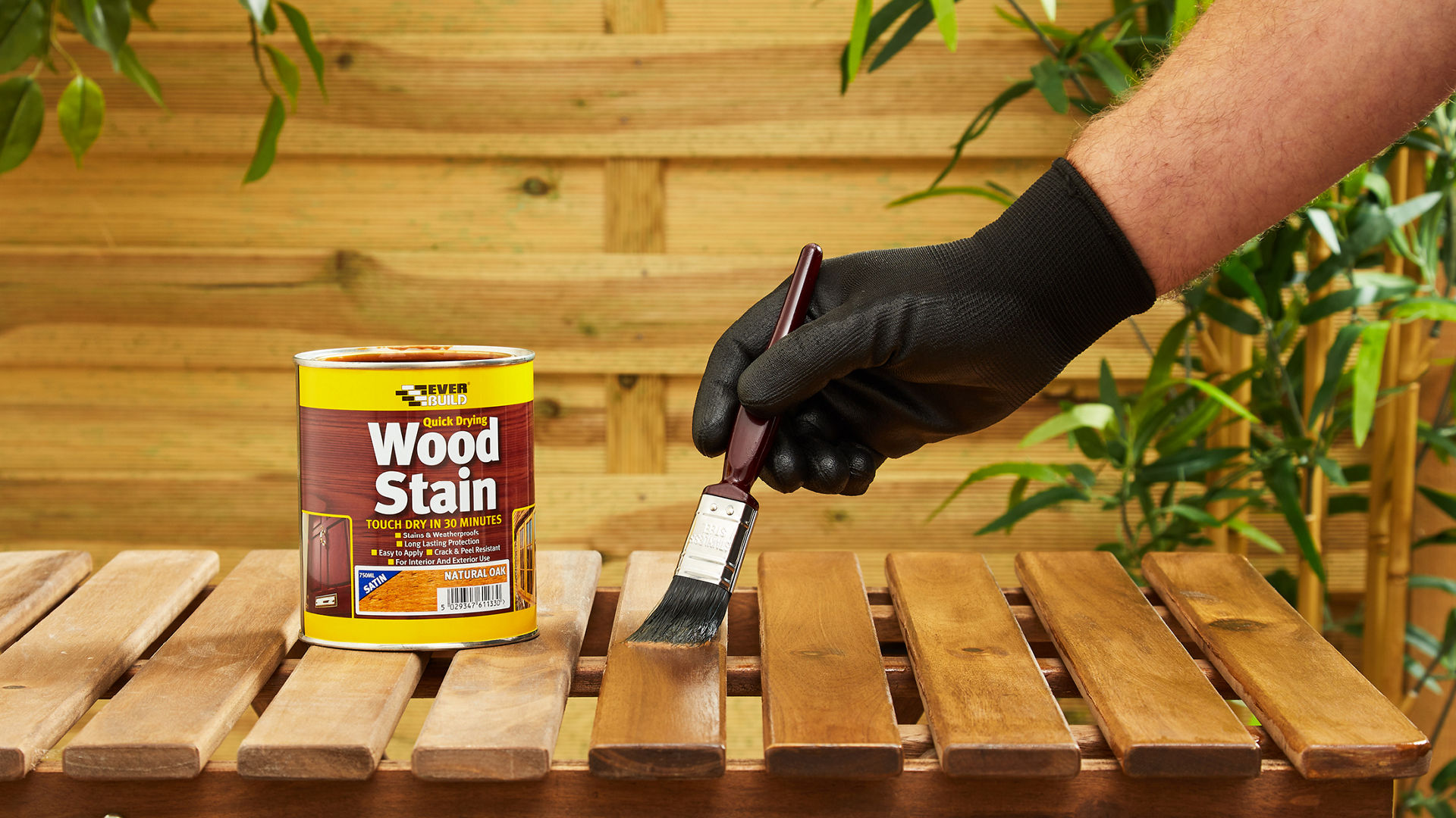 Person applying wood stain to wooden table