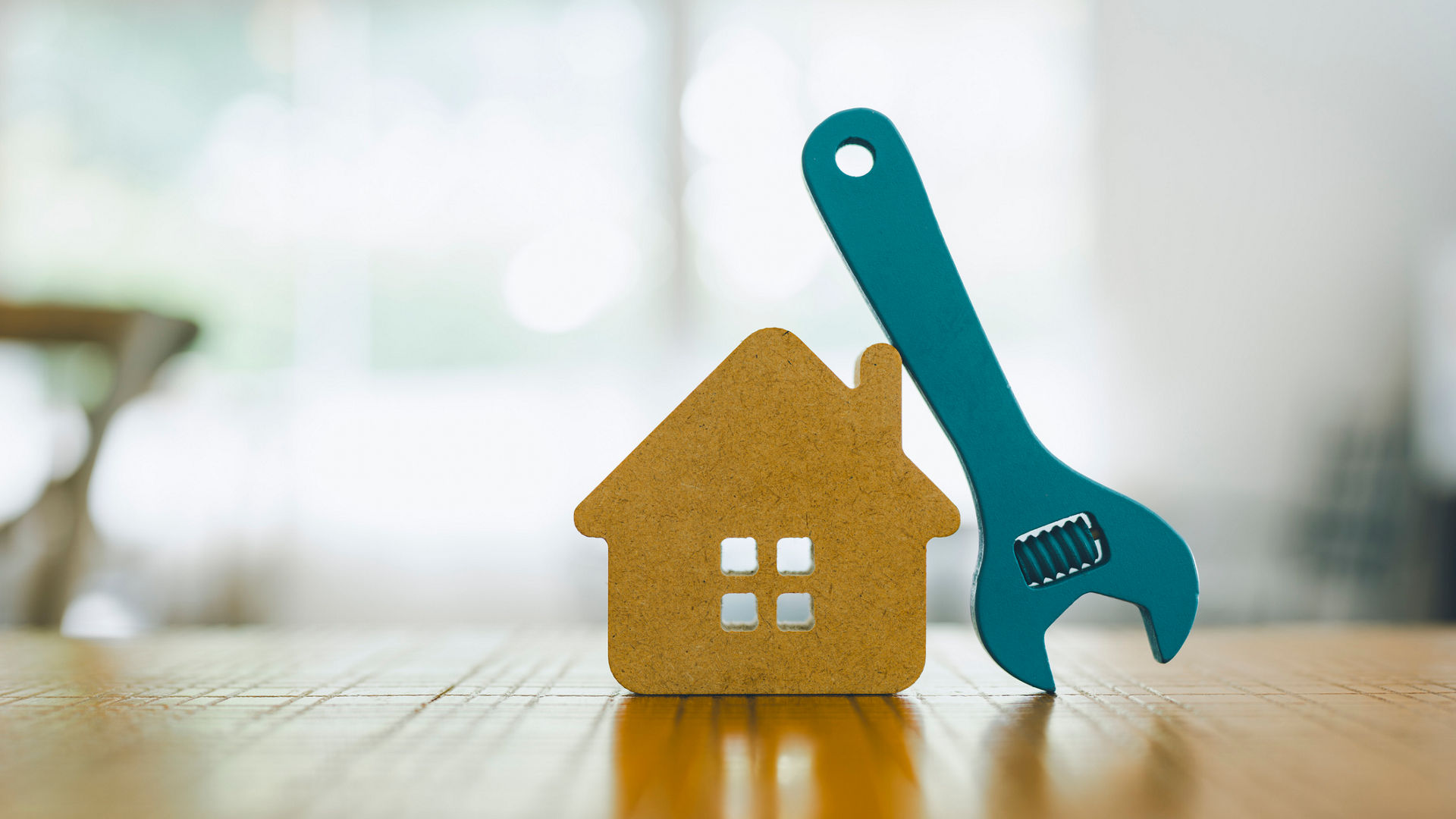 Wooden House Model with Blue Wrench Indoors