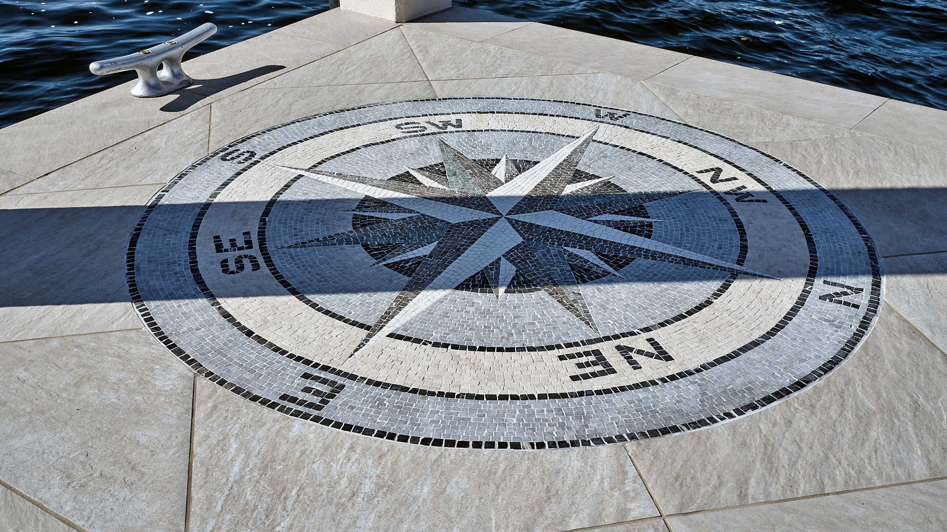 Mosaic compass rose on dock.