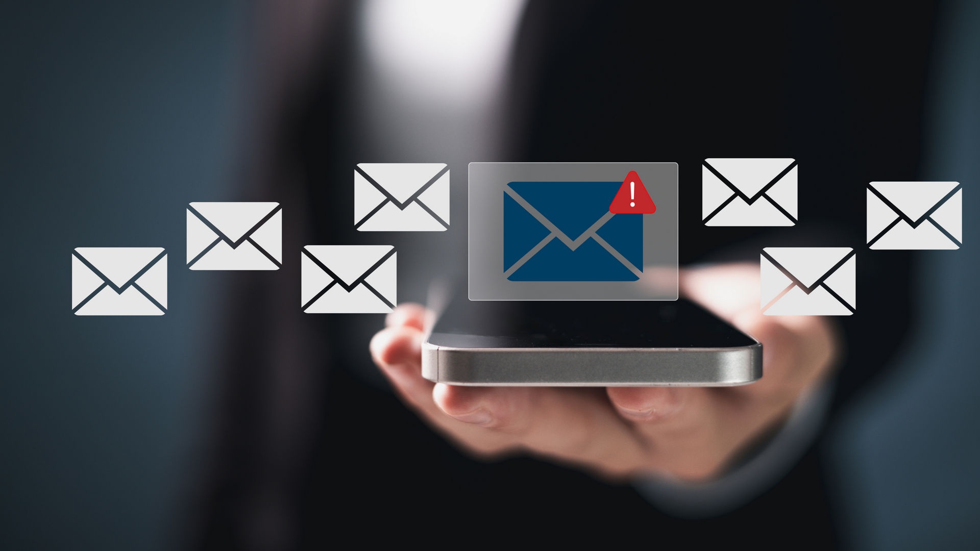 Hand holding smartphone with email alert