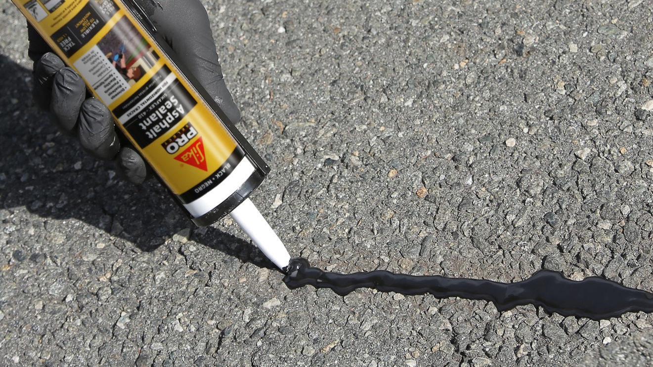 Sikaflex Asphalt Sealant Application With Caulk Gun On Driveway Crack