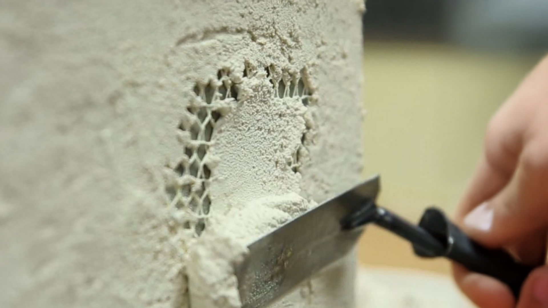 Applying plaster to wall with tool