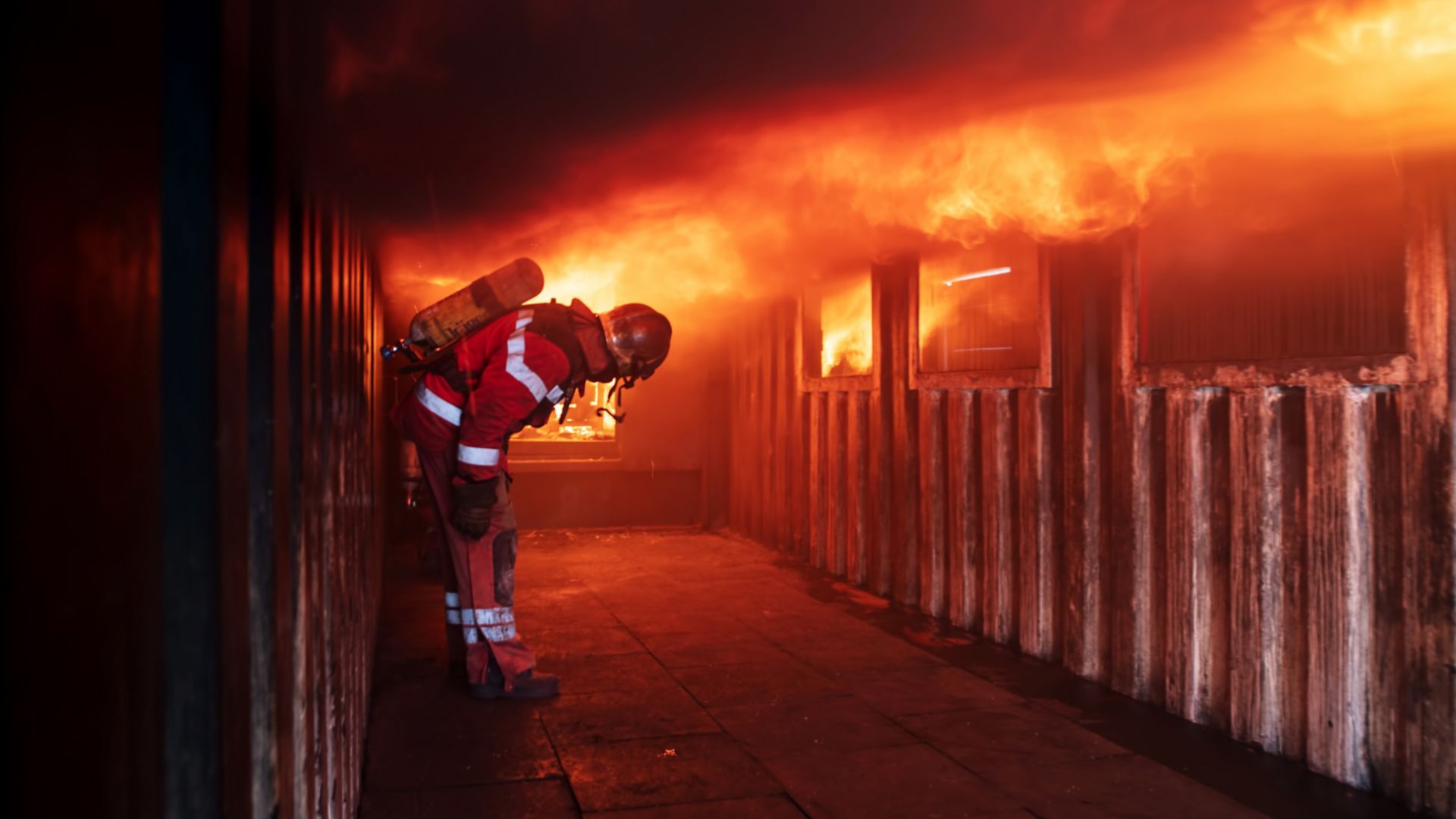 Fireman in front of house on fire