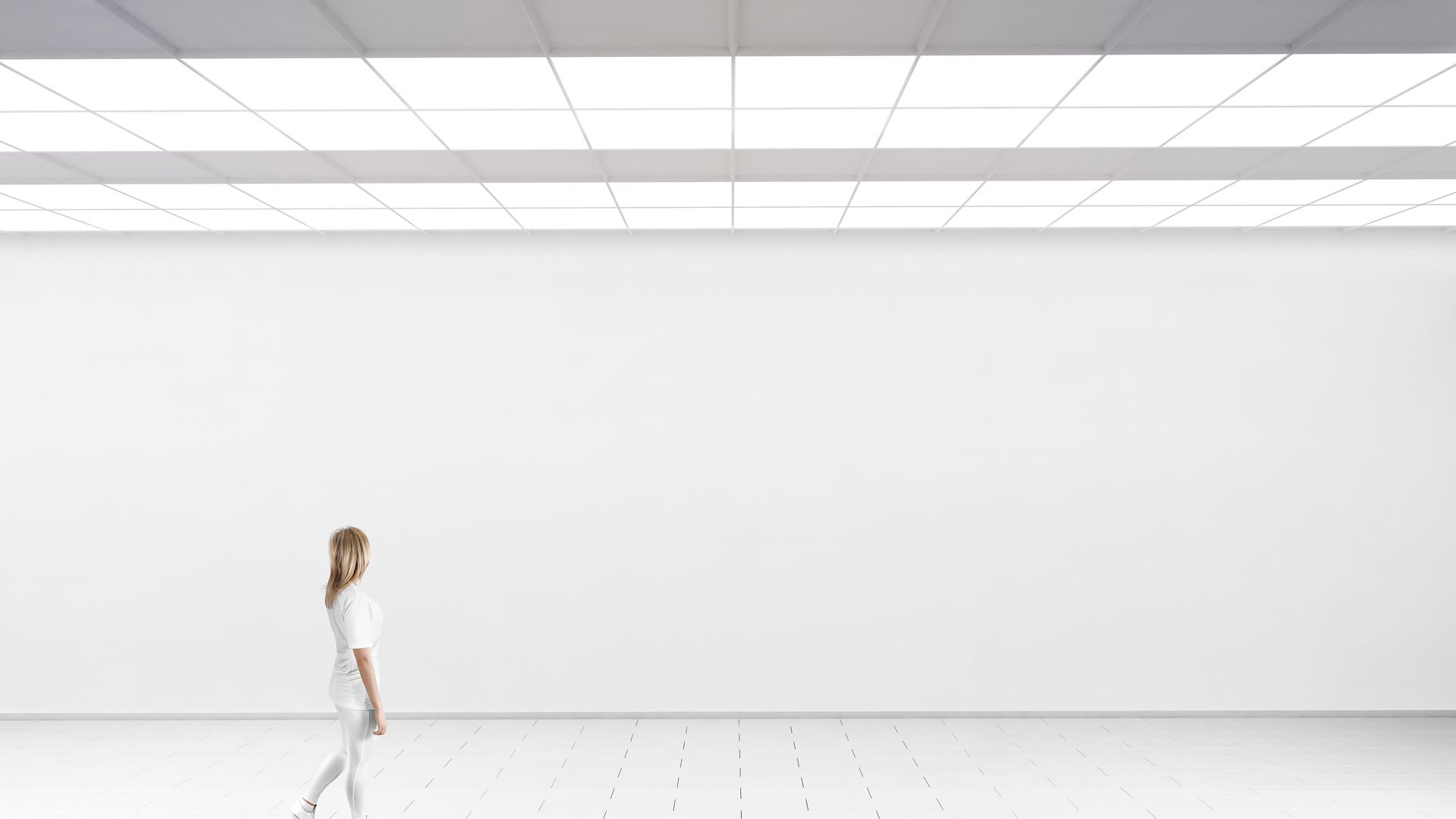 Woman walking in front of a white wall
